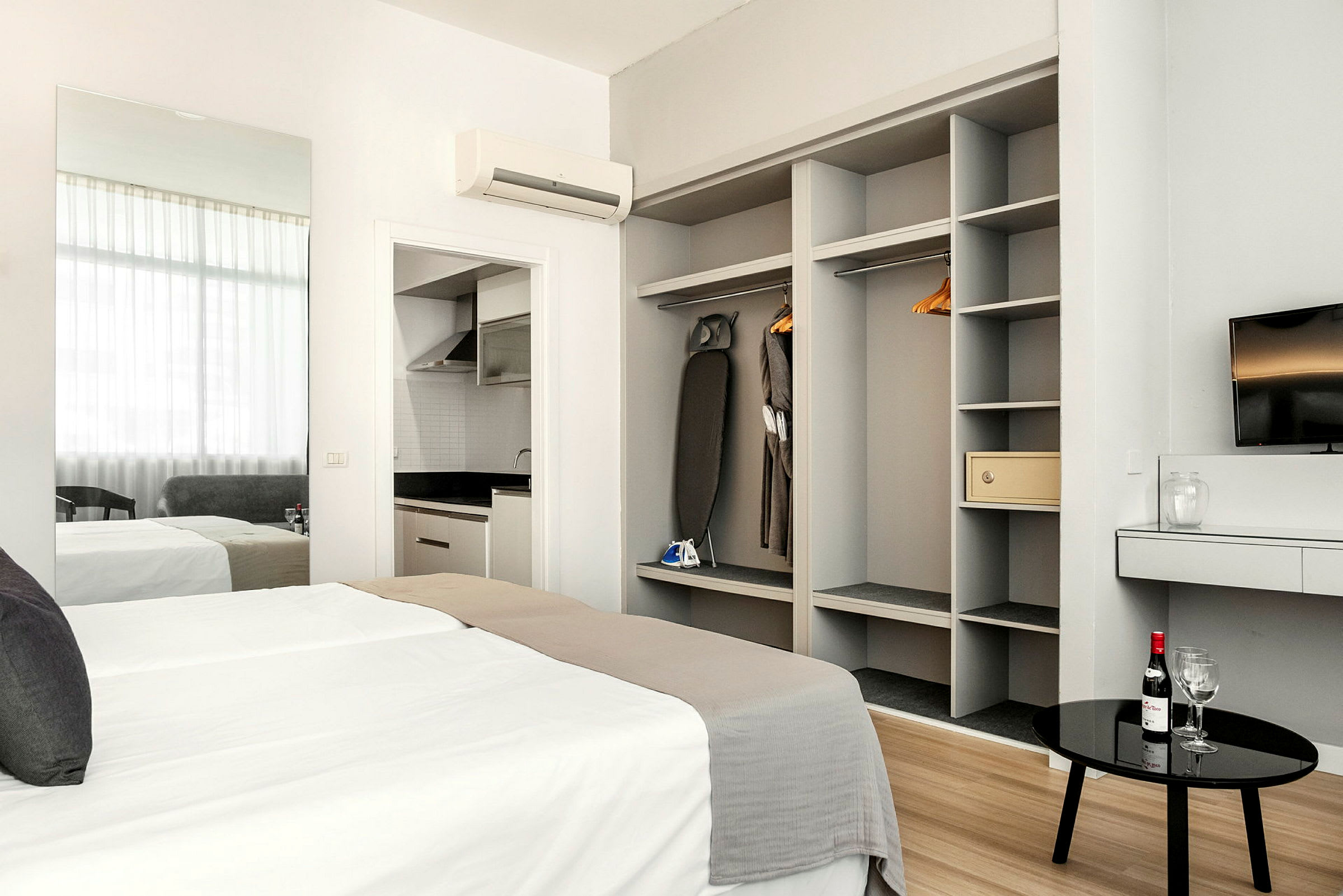 Modernt hotellrum med säng, garderob, en TV och köksavdelning. (AI-genererad text)