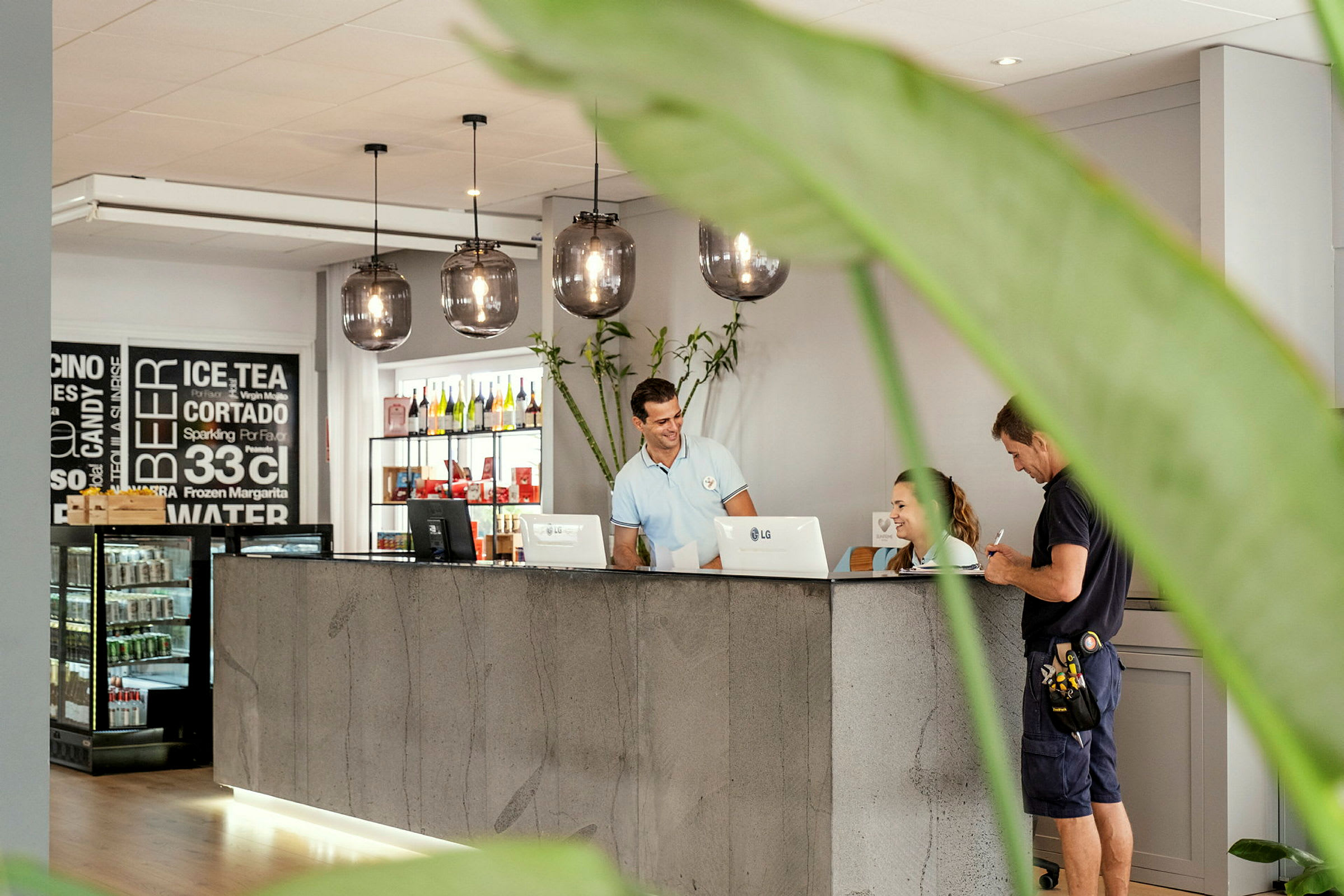 Reception med en betongdisk, hängande lampor och växtdekorationer. (AI-genererad text)