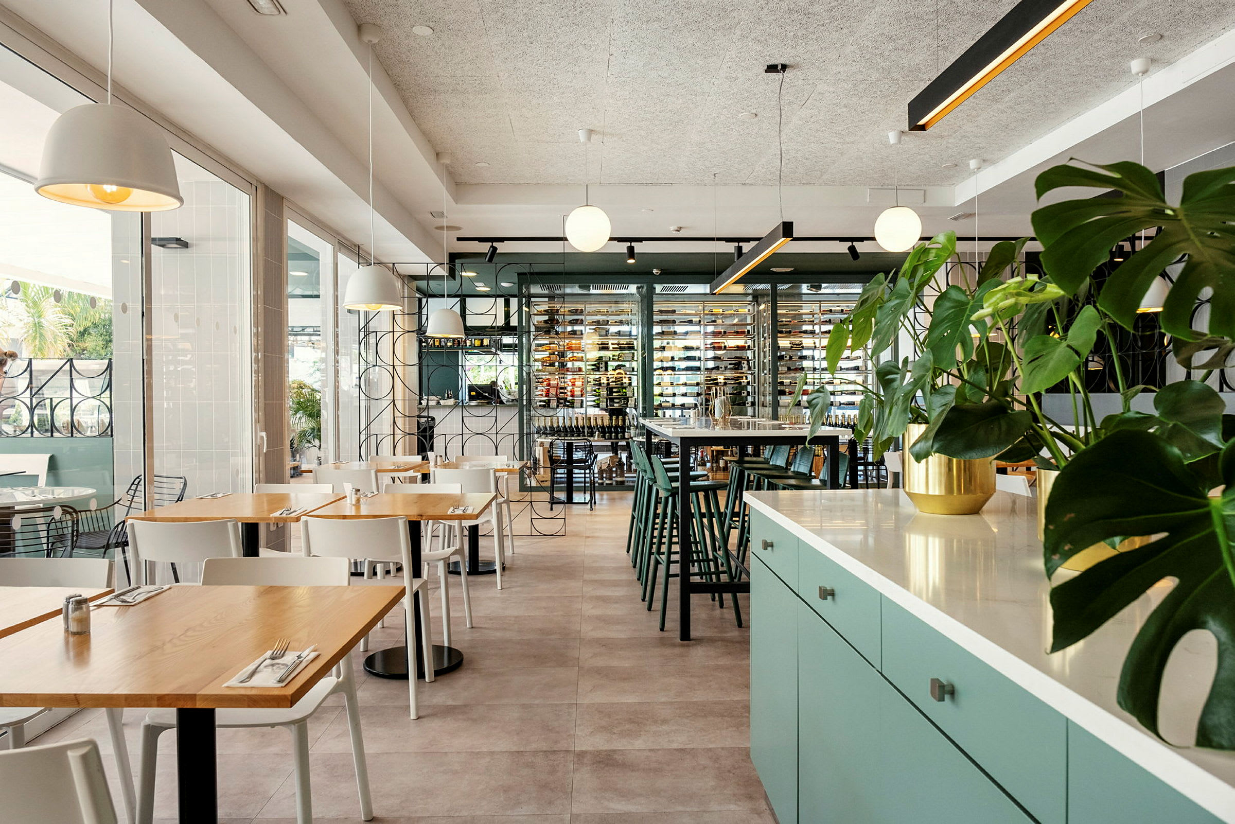 Interiör av en modern restaurang med sittgrupper och gröna växter. (AI-genererad text)