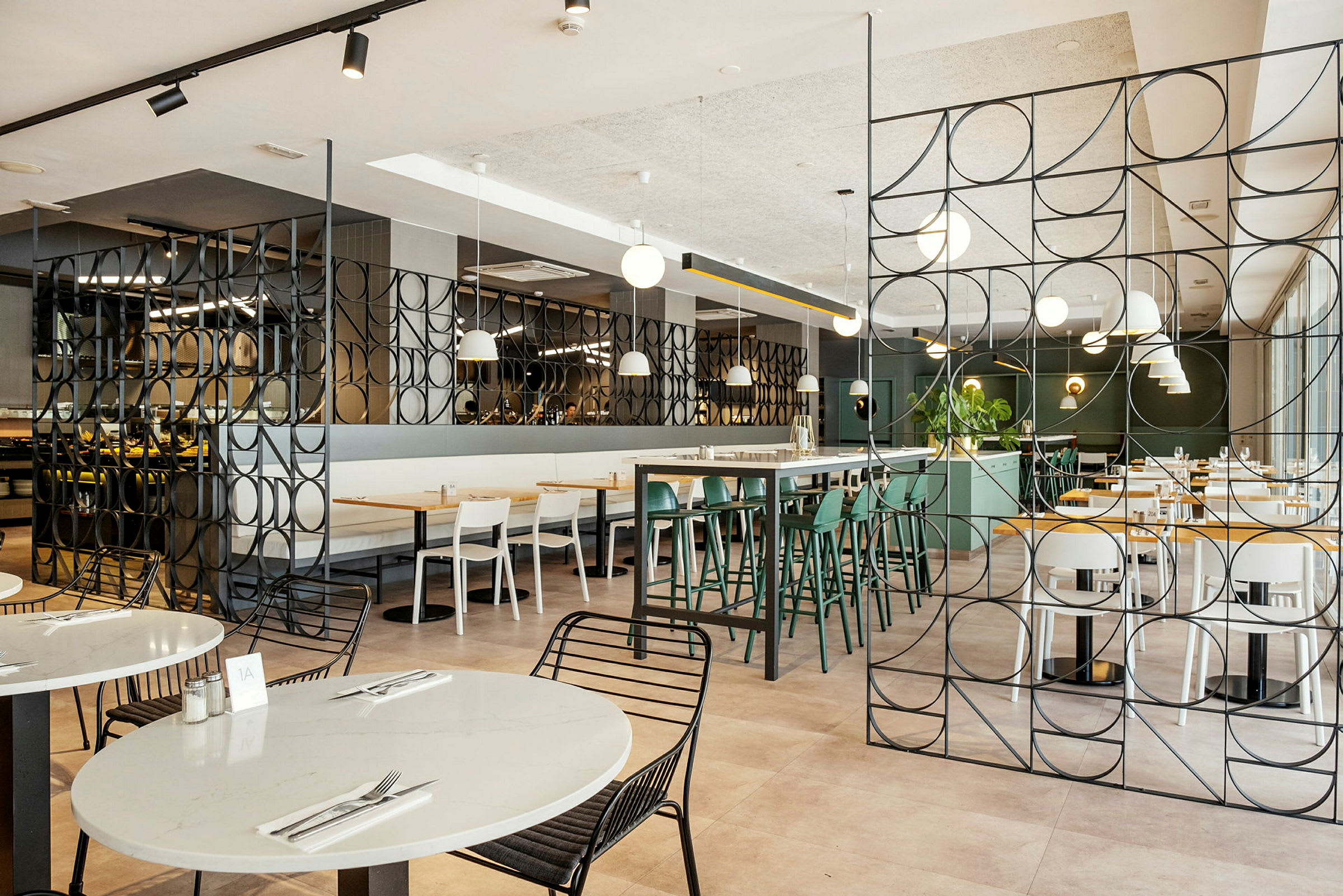 Interiör av en modern restaurang med bord och stolar samt dekorativa metallpaneler. (AI-genererad text)