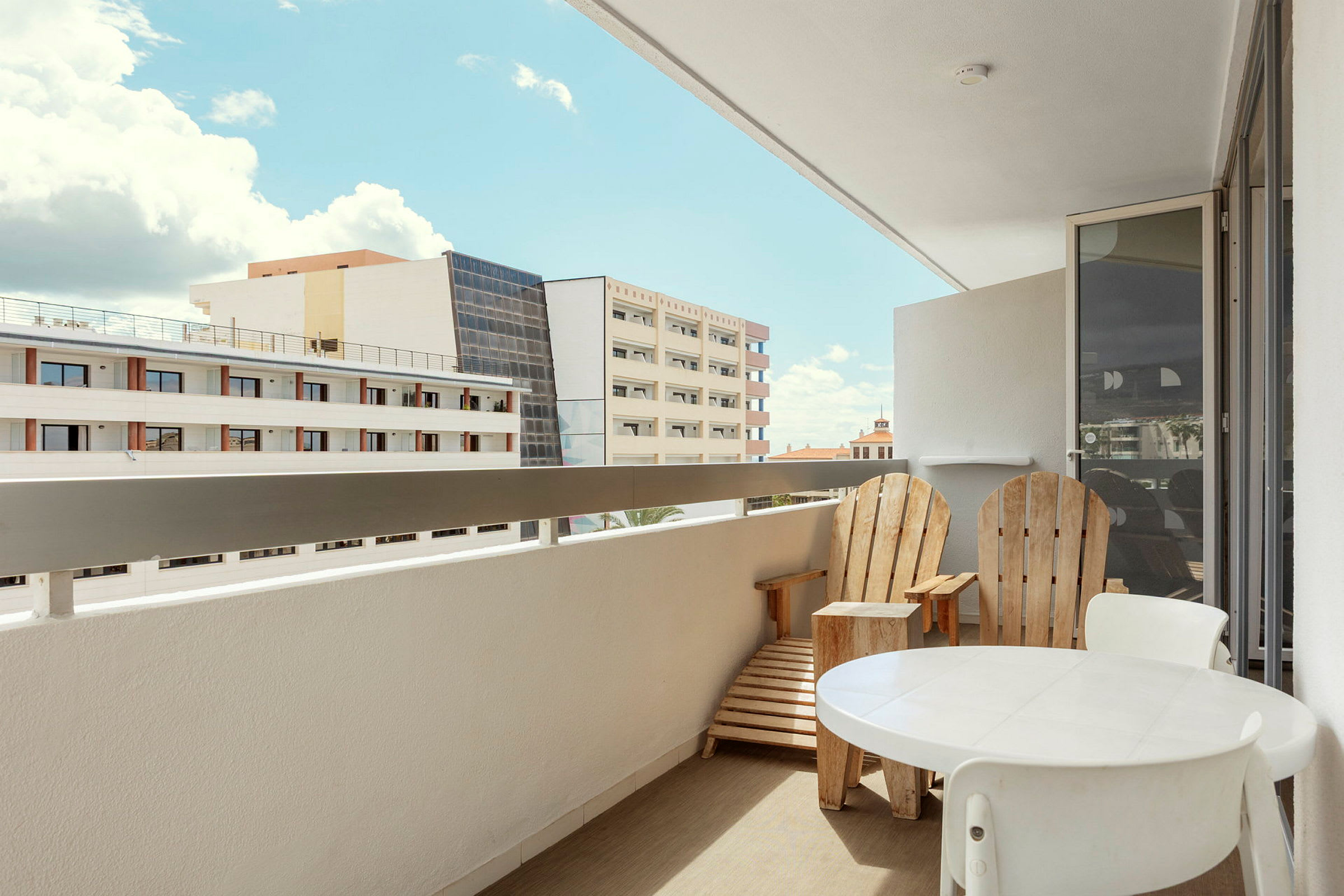 En balkong med sittmöbler och utsikt över ett hotellområde. (AI-genererad text)