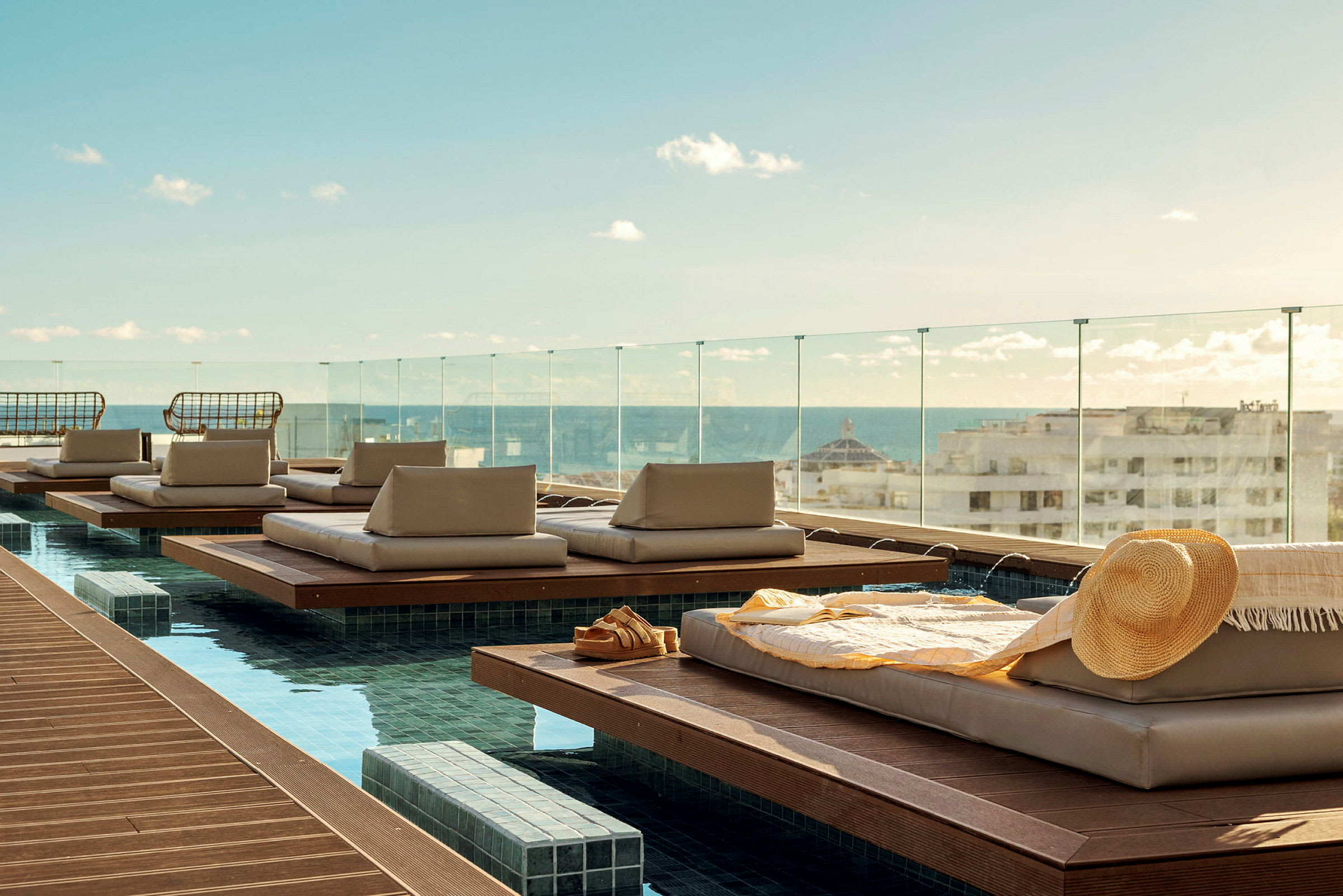 Liggplatser vid en pool med utsikt över staden och havet. (AI-genererad text)