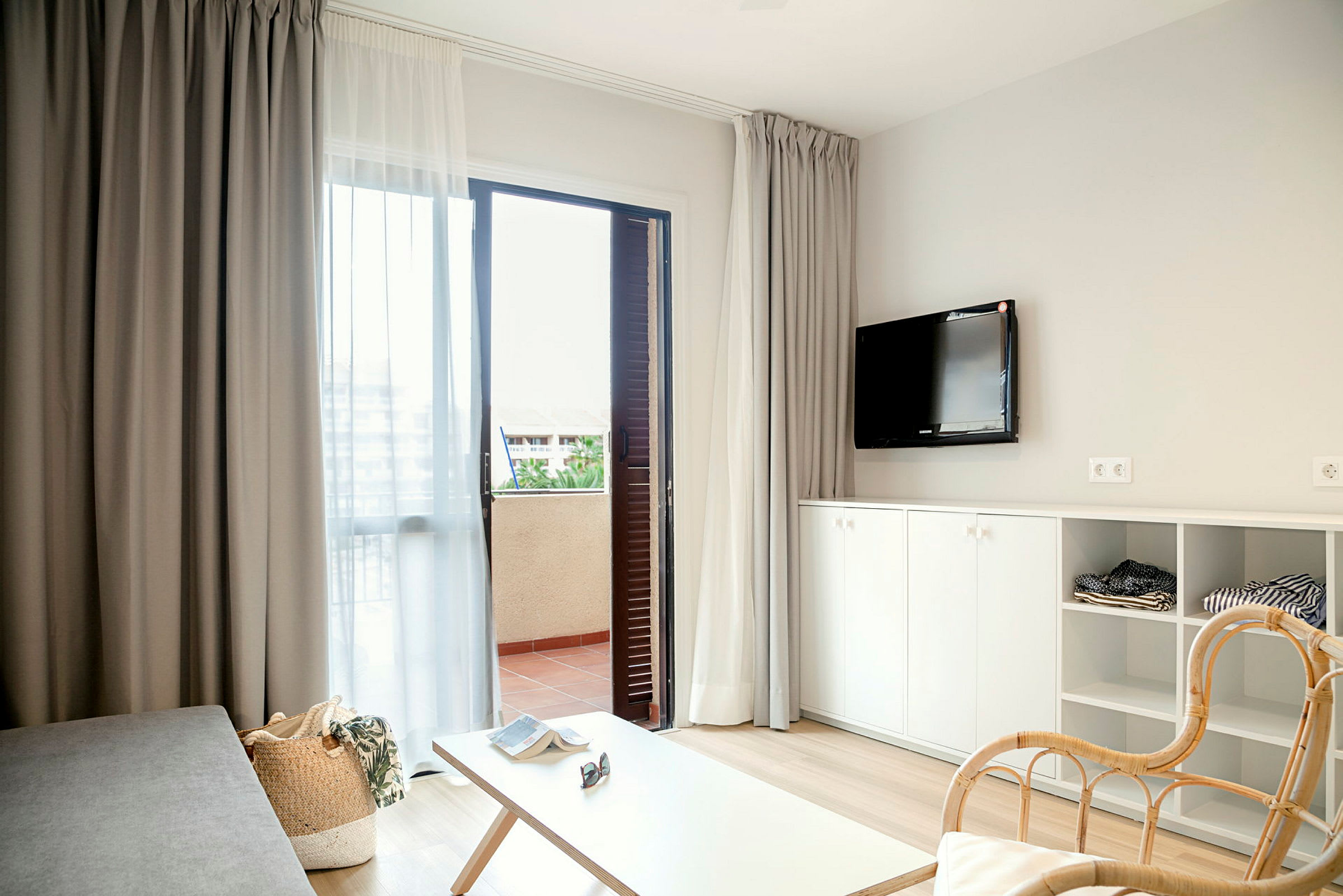 Modernt möblerat hotellrum med öppen dörr till balkong. (AI-genererad text)