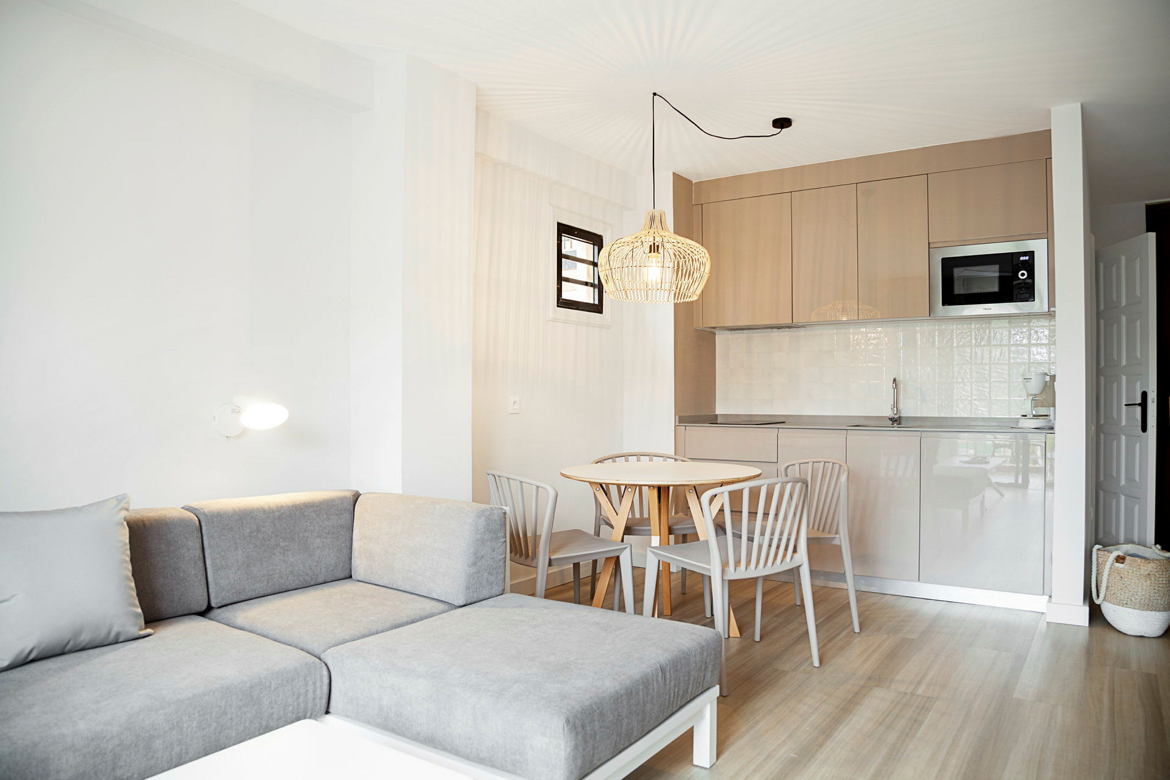 En ljus lägenhet med modern soffa, matbord och kök. (AI-genererad text)