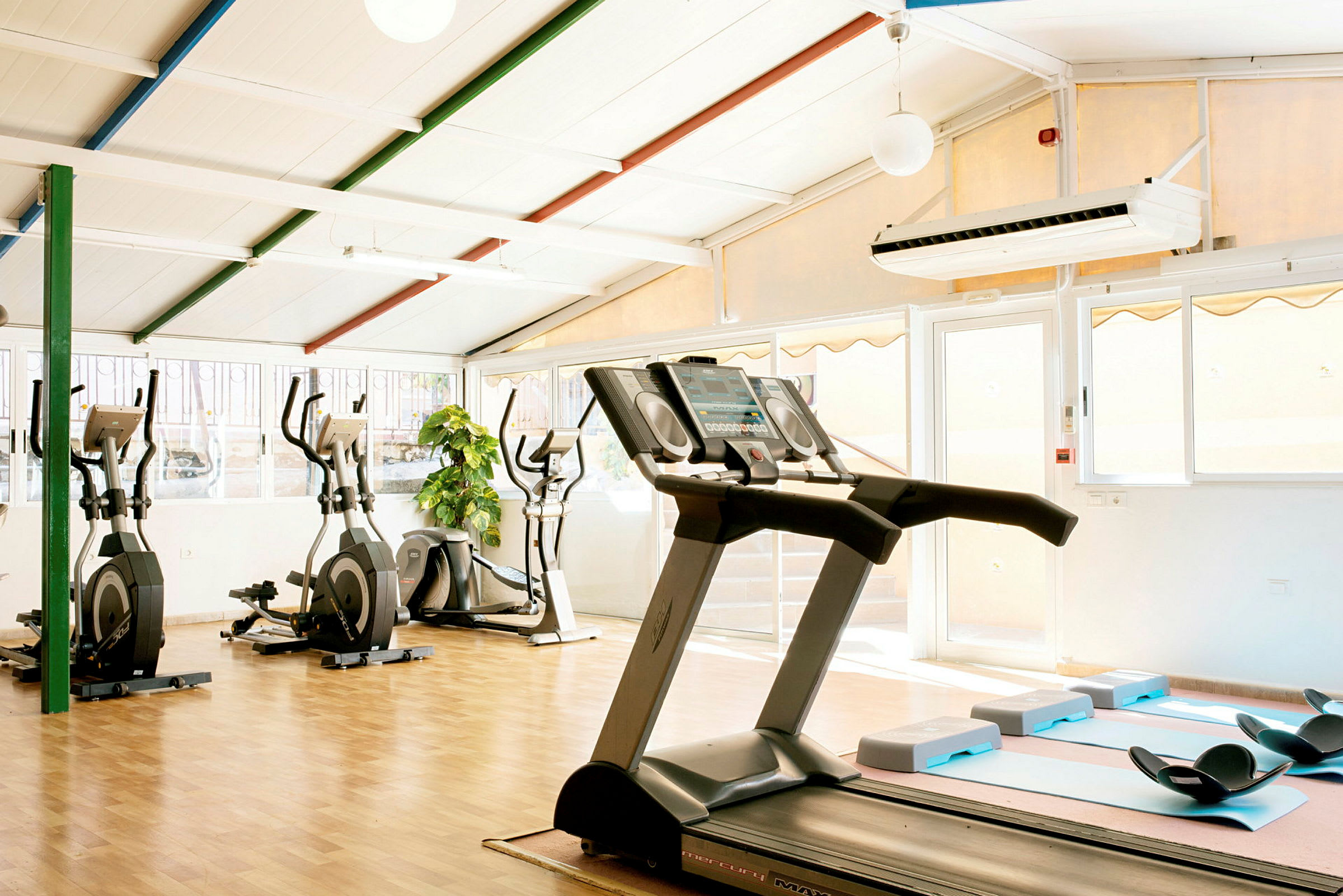 Bild av ett gym med träningsmaskiner och ljus interiör. (AI-genererad text)