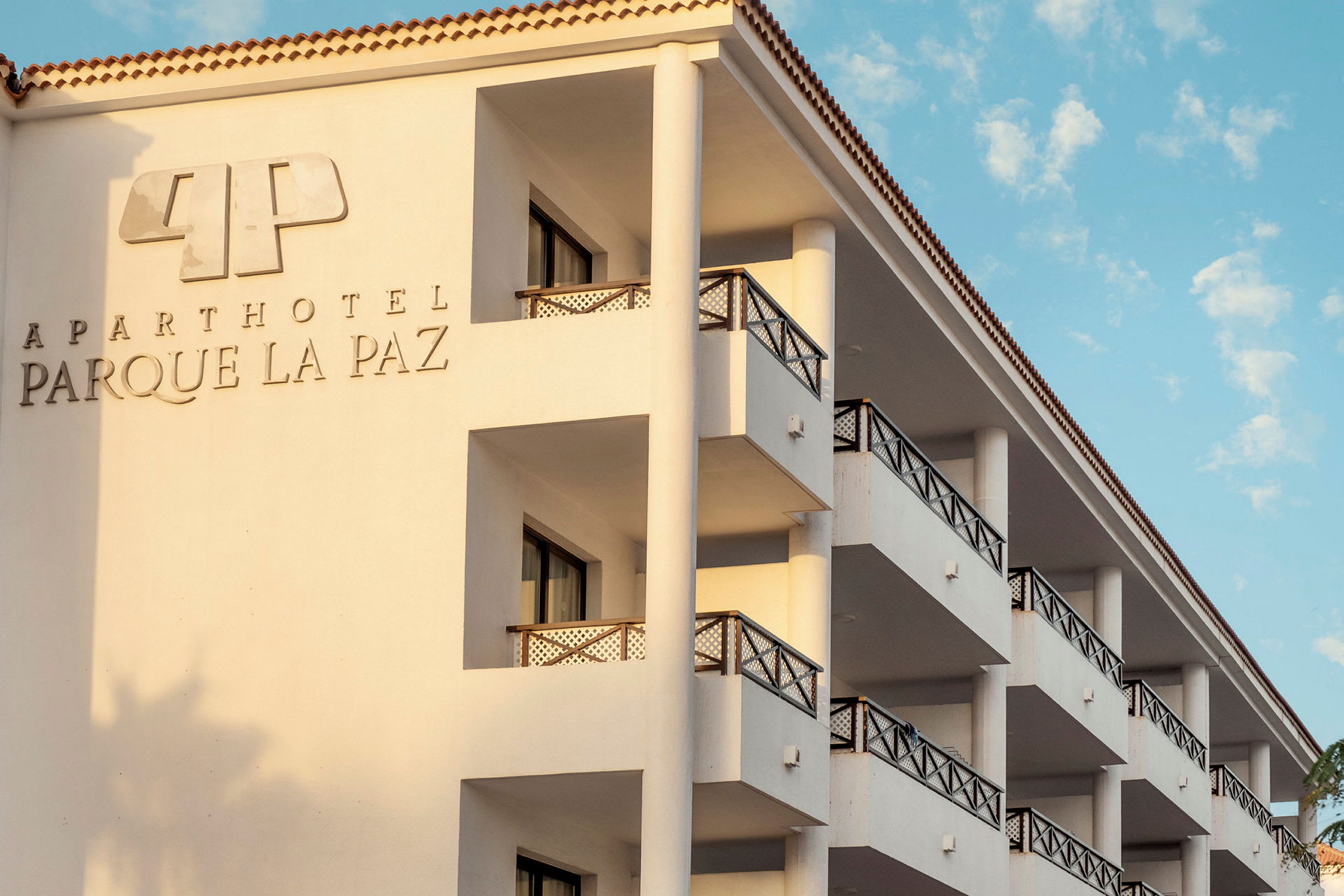 Byggnad med balkonger och hotellnamn på fasaden. (AI-genererad text)