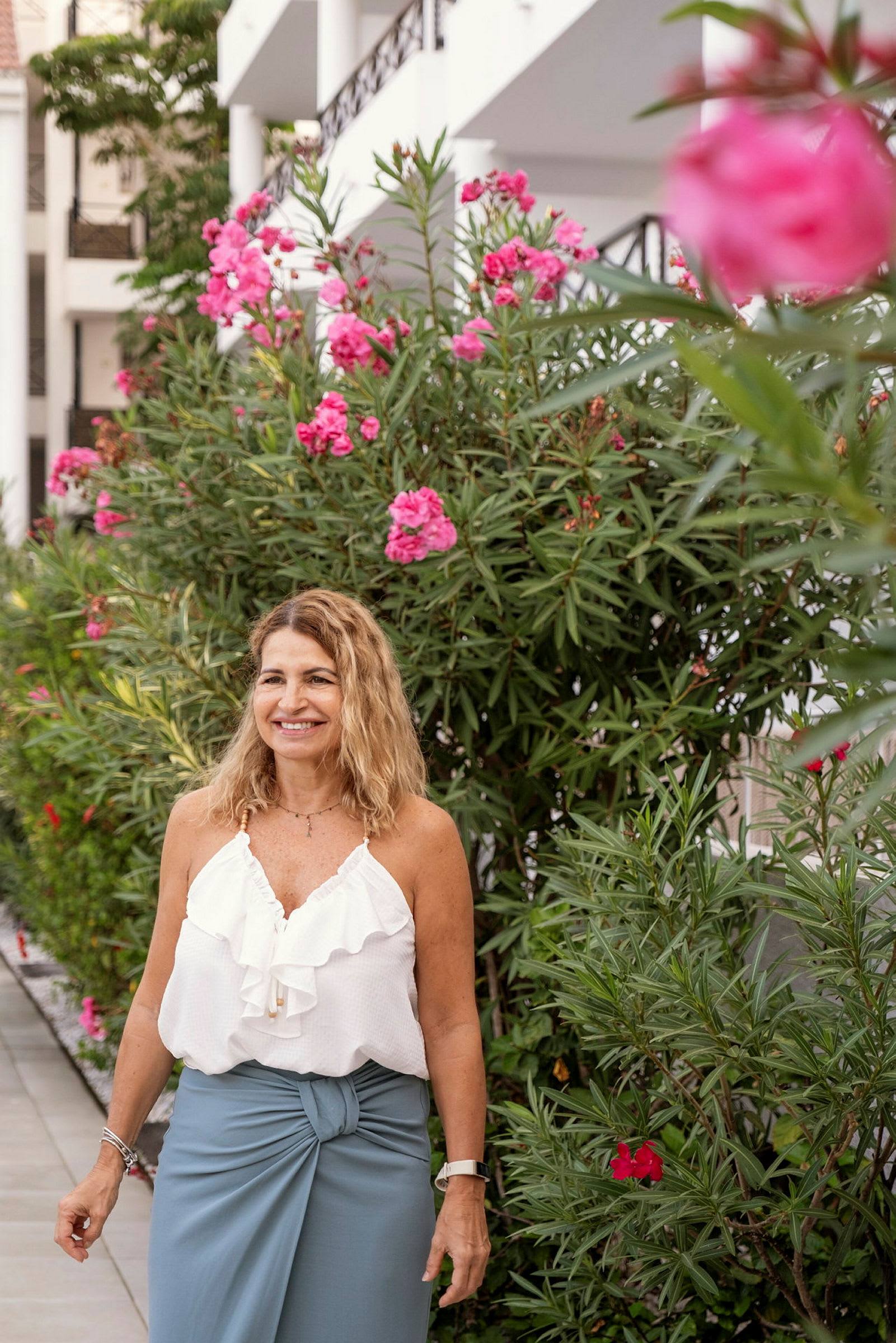 Blommande rosa blommor vid sidan av en byggnad. (AI-genererad text)