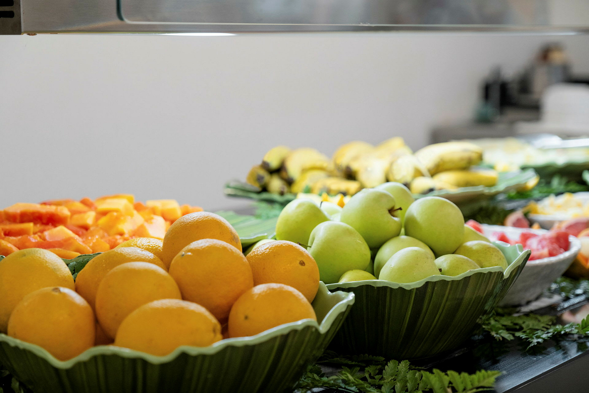 En buffé med olika frukter som apelsiner, gröna äpplen och bananer. (AI-genererad text)