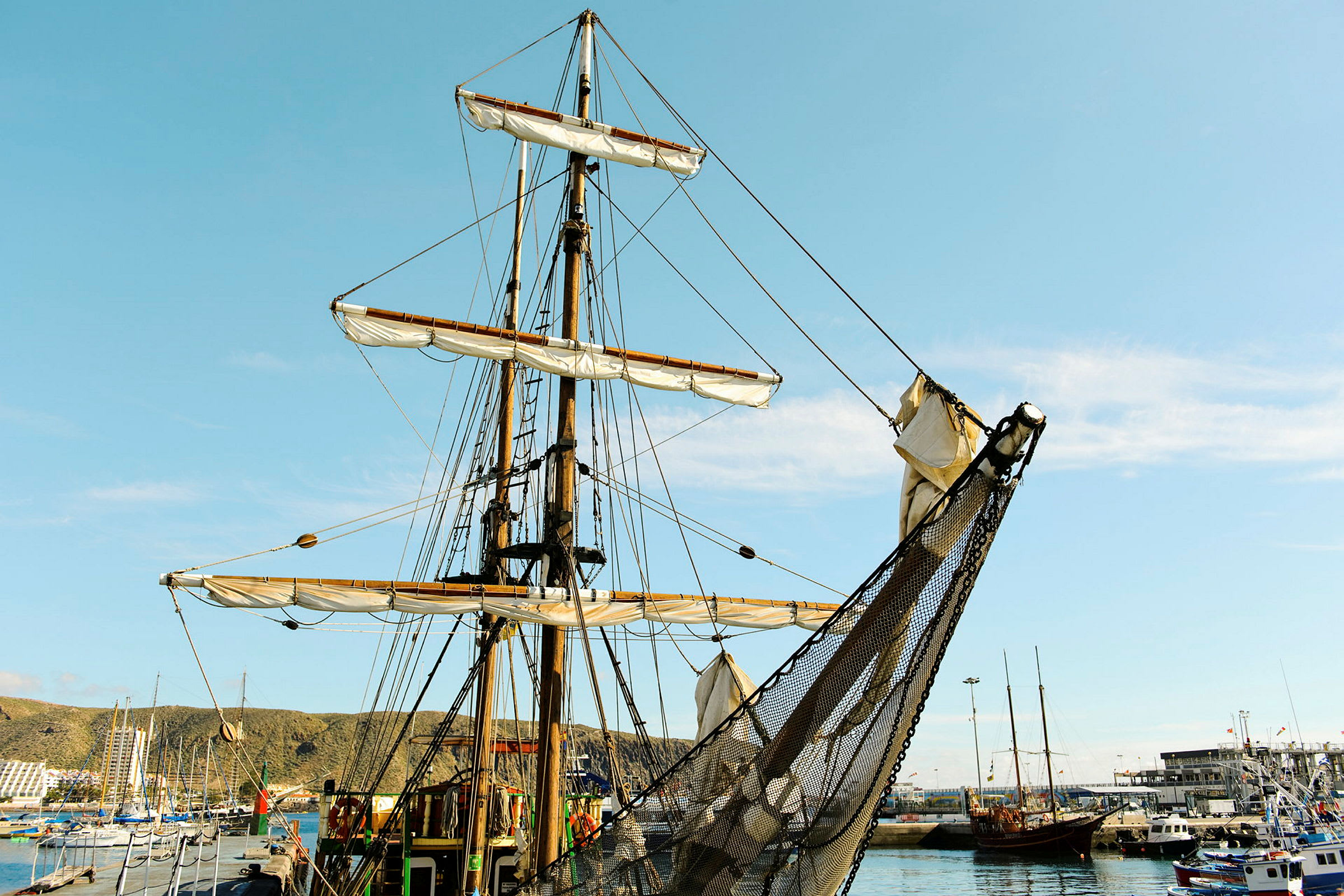 Segelfartyg i hamn med blå himmel i bakgrunden. (AI-genererad text)