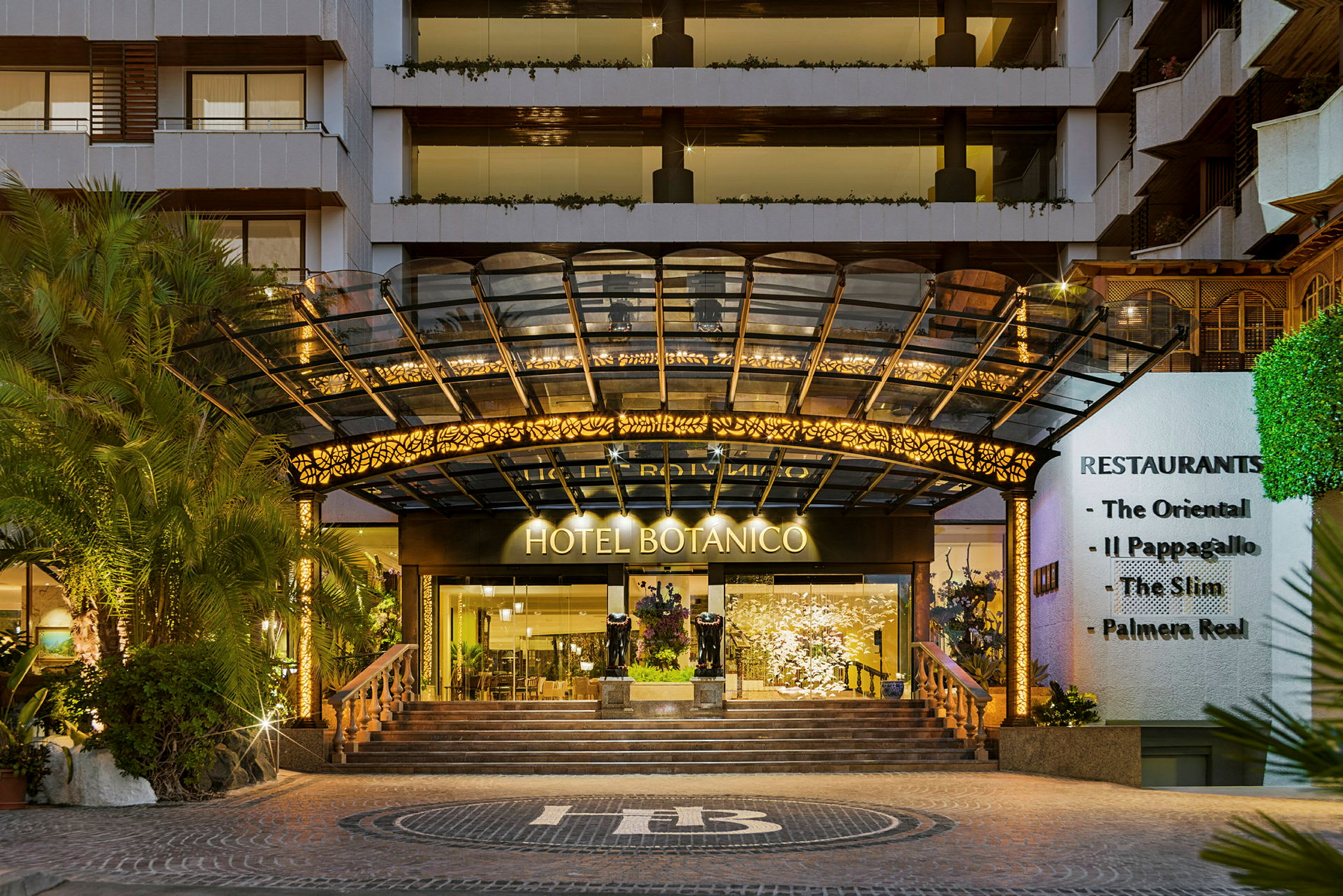 Entrén till Hotel Botanico med dekorerade trappor och tak. (AI-genererad text)