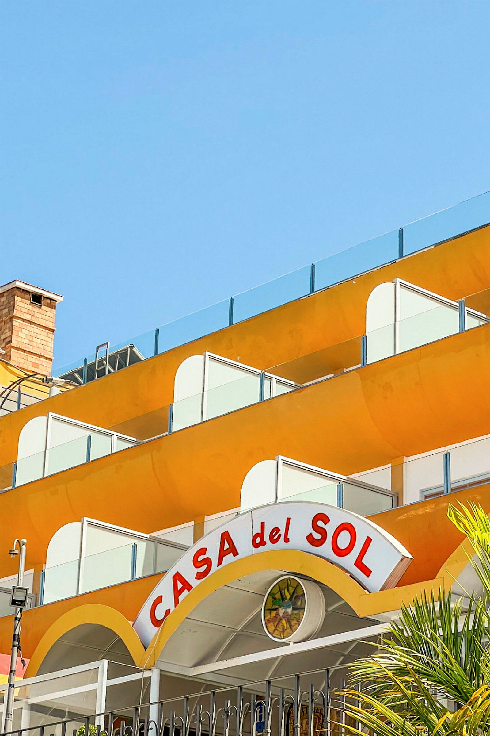 En byggnad med gula balkonger och en skylt med texten "Casa del Sol". (AI-genererad text)