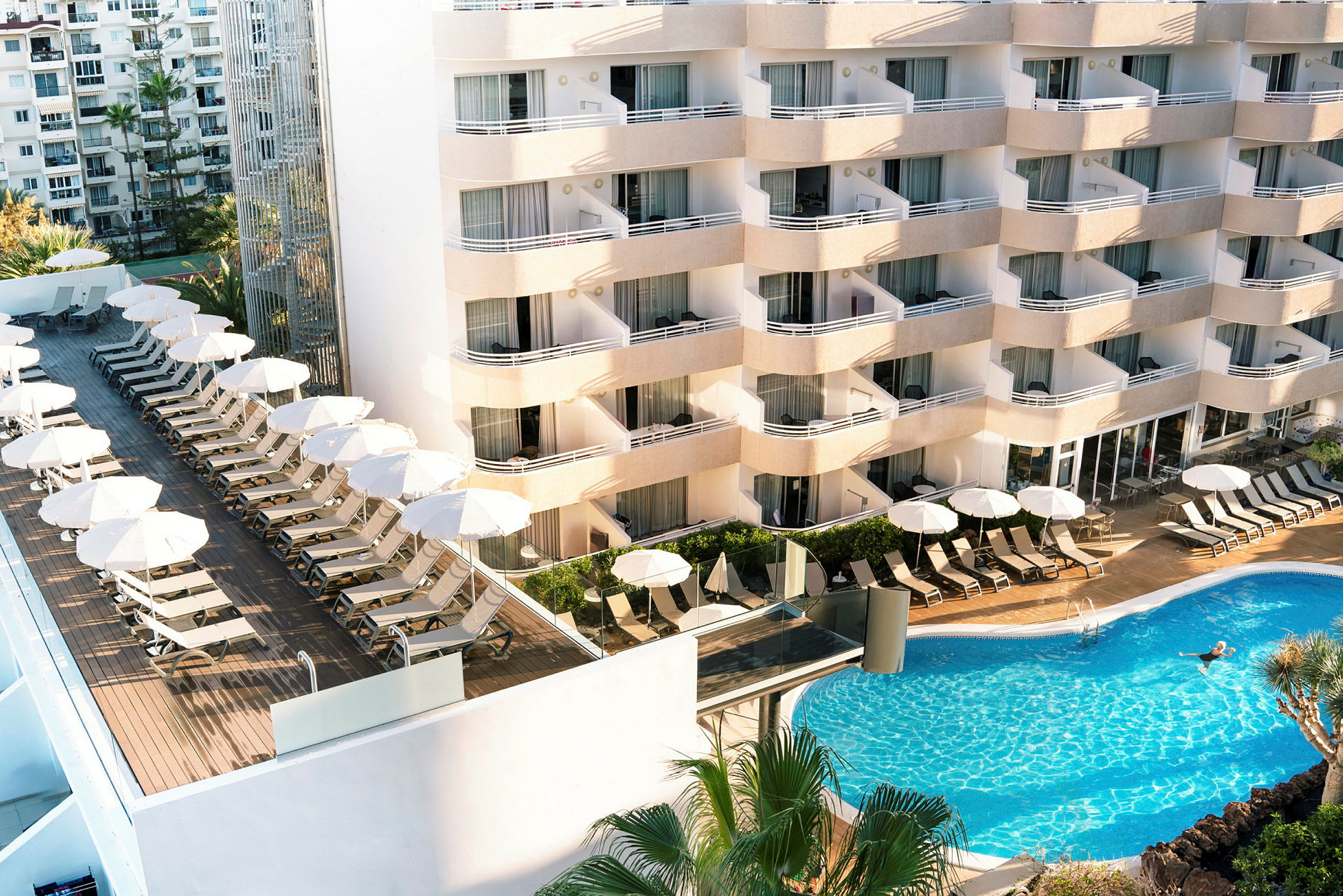 Bild av hotell med solstolar, parasoller och pool. (AI-genererad text)