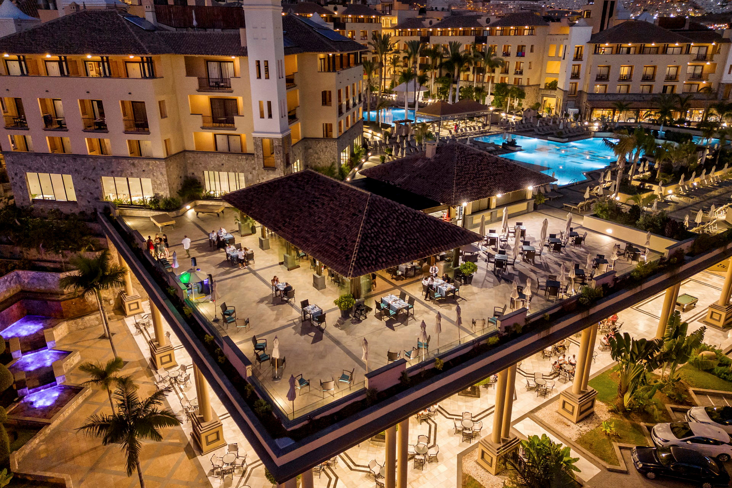 Utomhuspoolområde vid lyxhotell med restaurang och sittplatser. (AI-genererad text)