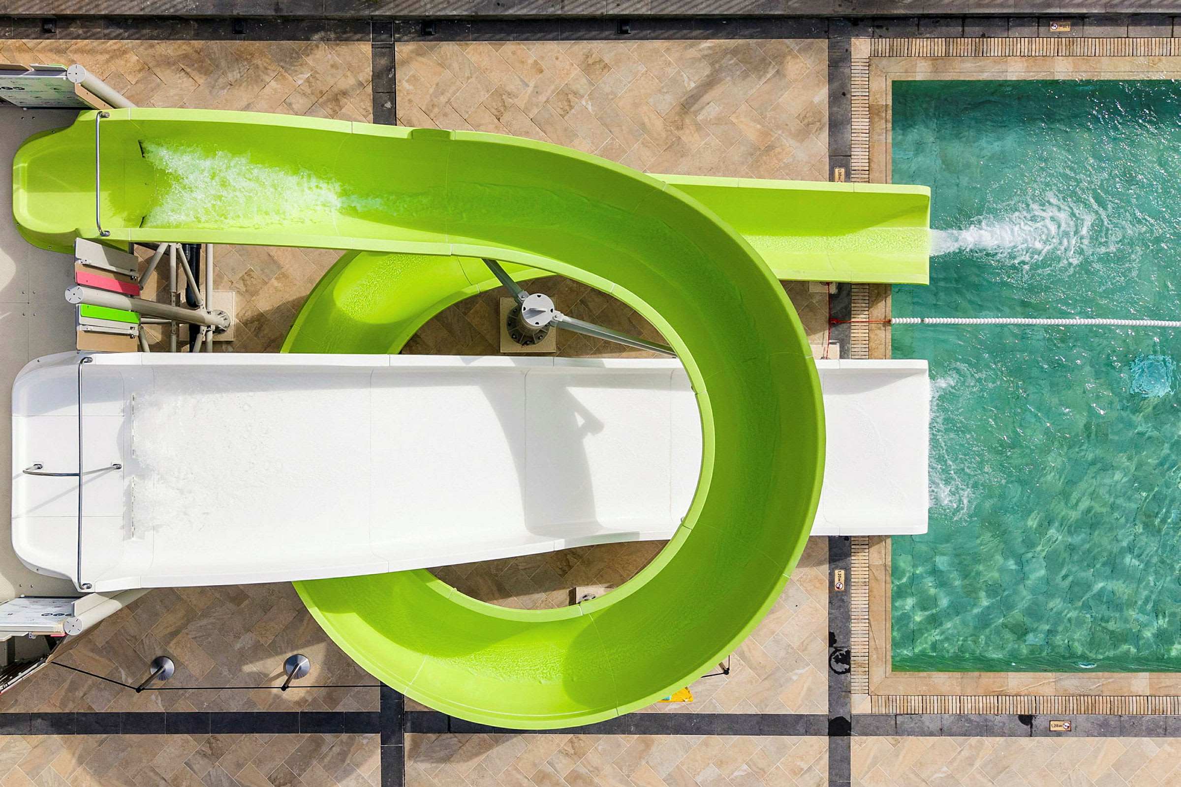 Luftfoto av en kurvig vattenrutschkana vid en pool. (AI-genererad text)