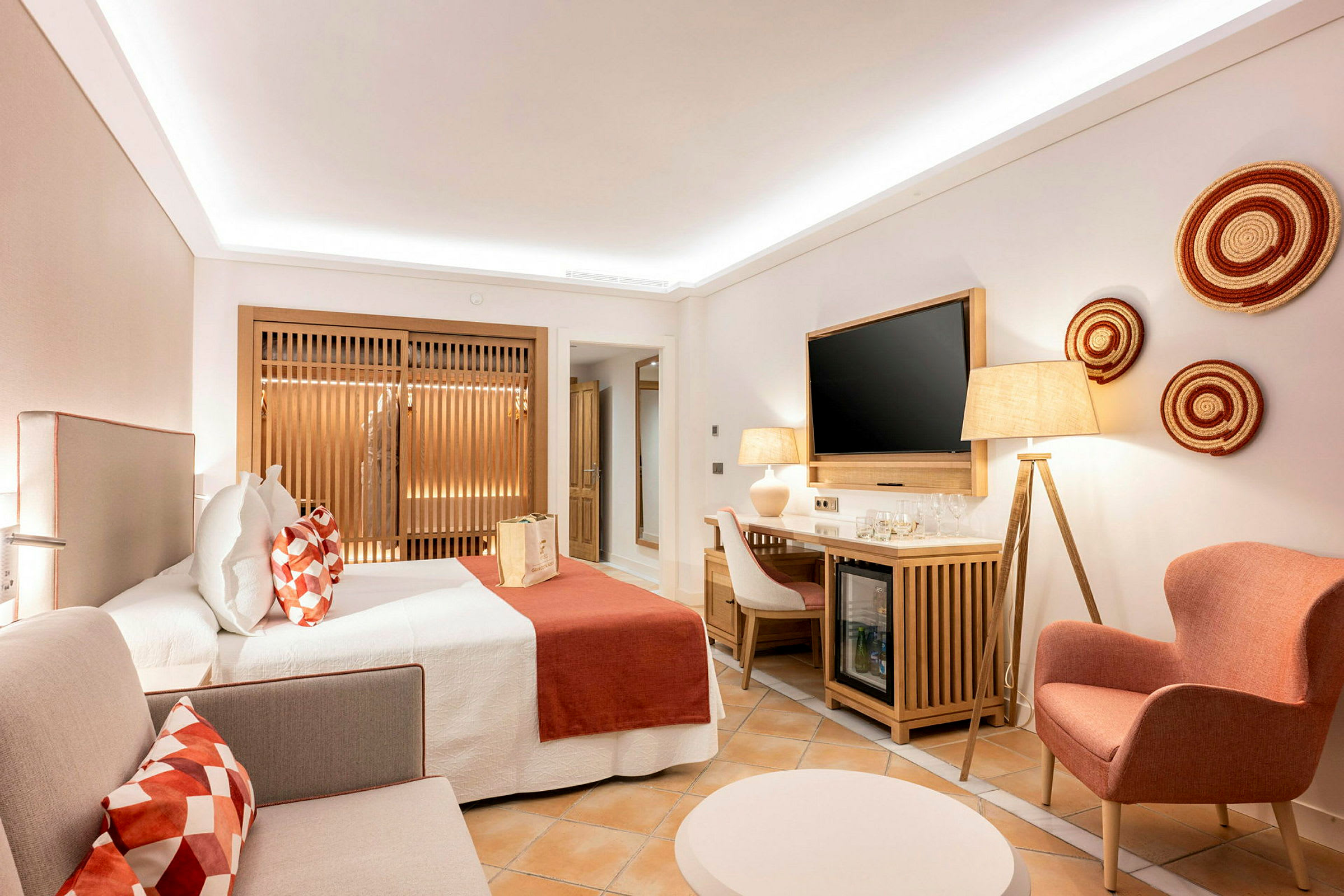 Ett hotellrum med modern inredning, en dubbelsäng, sittmöbler och en TV. (AI-genererad text)