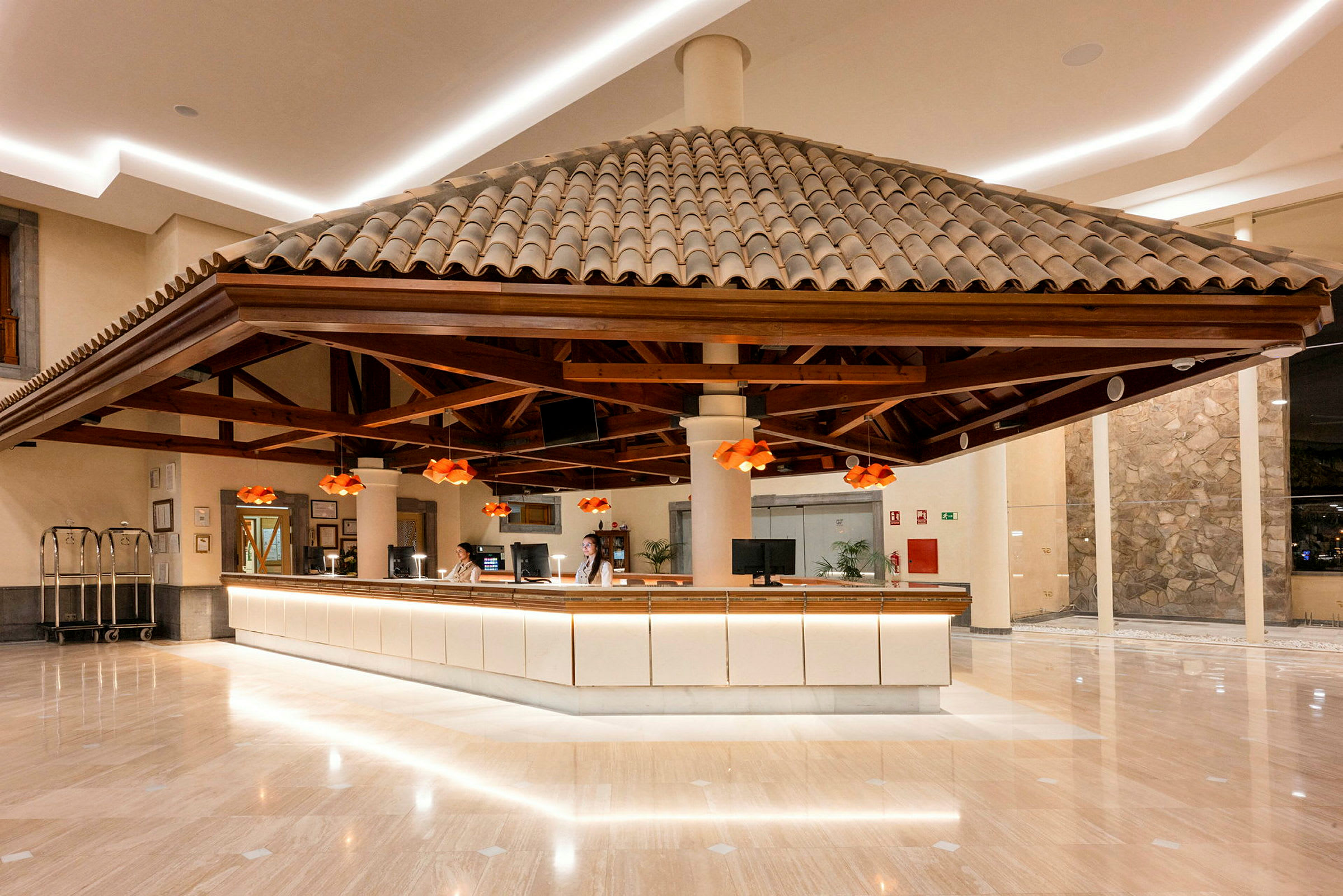 Receptionen i hotellbyggnaden med ett takdekoration och orange lampor. (AI-genererad text)