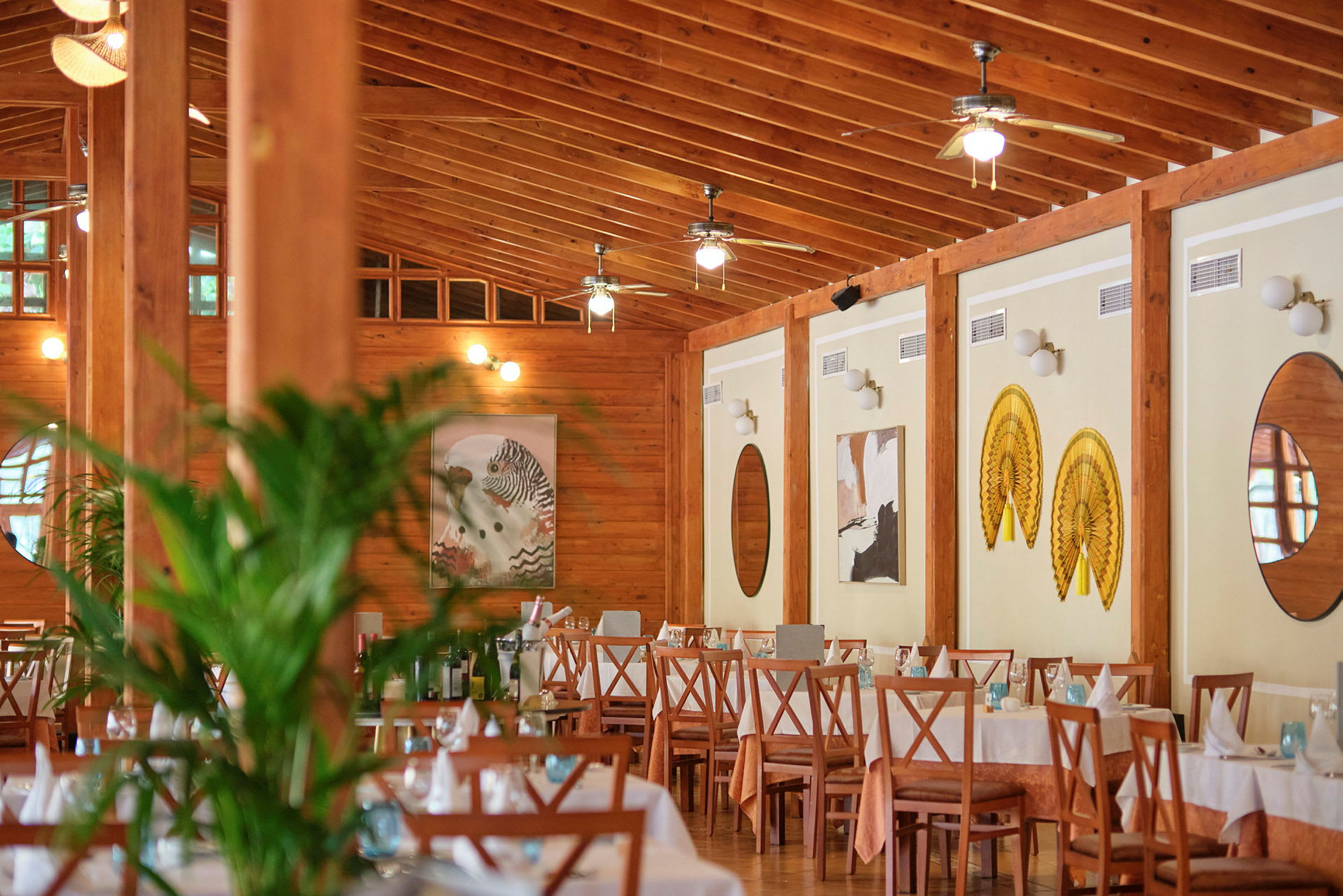 Interiören av en restaurang med dukade bord och träinredning. (AI-genererad text)