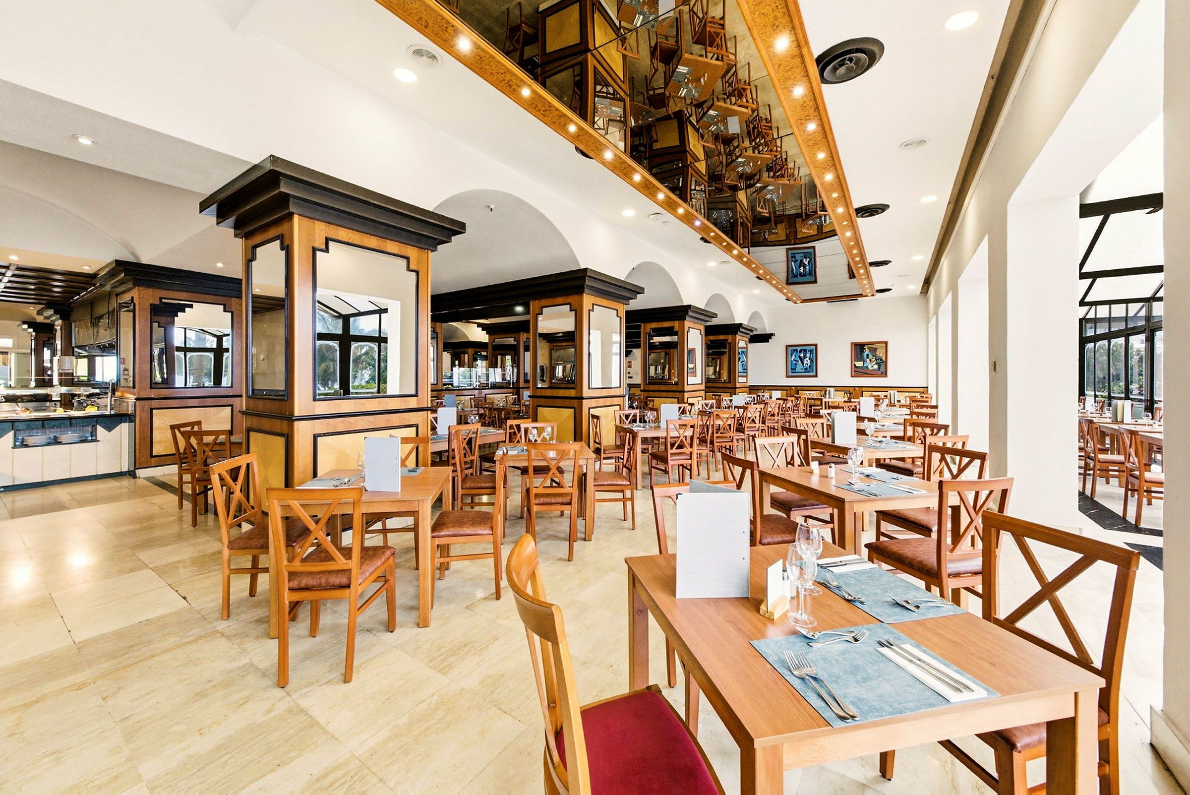 Ett rymligt och väl upplyst restaurangutrymme med träinredning och flera uppställda bord och stolar. (AI-genererad text)