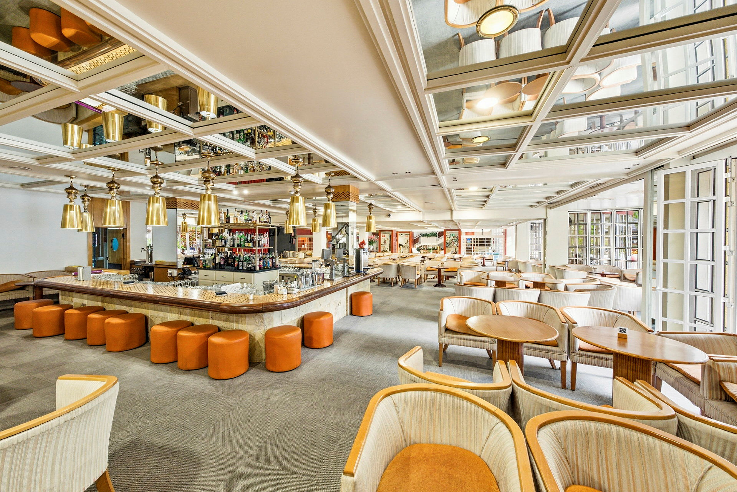 Bild av en ljus och rymlig bar och lounge med moderna möbler och en central bardisk. (AI-genererad text)
