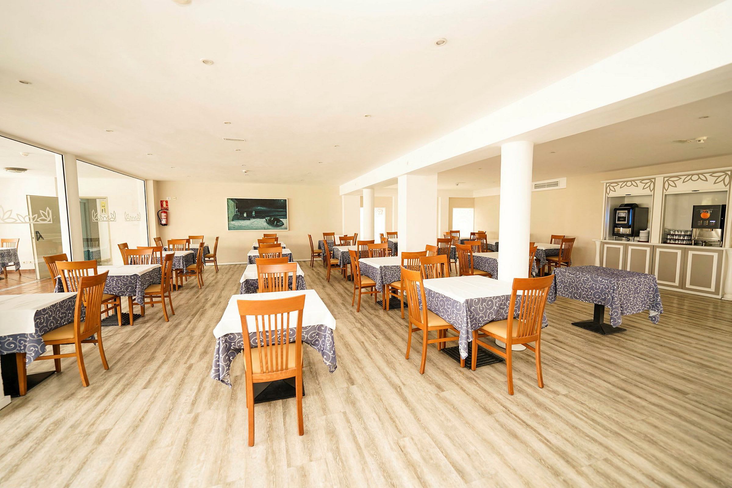 Restaurang med bord klädda i dukar och stolar av trä. (AI-genererad text)