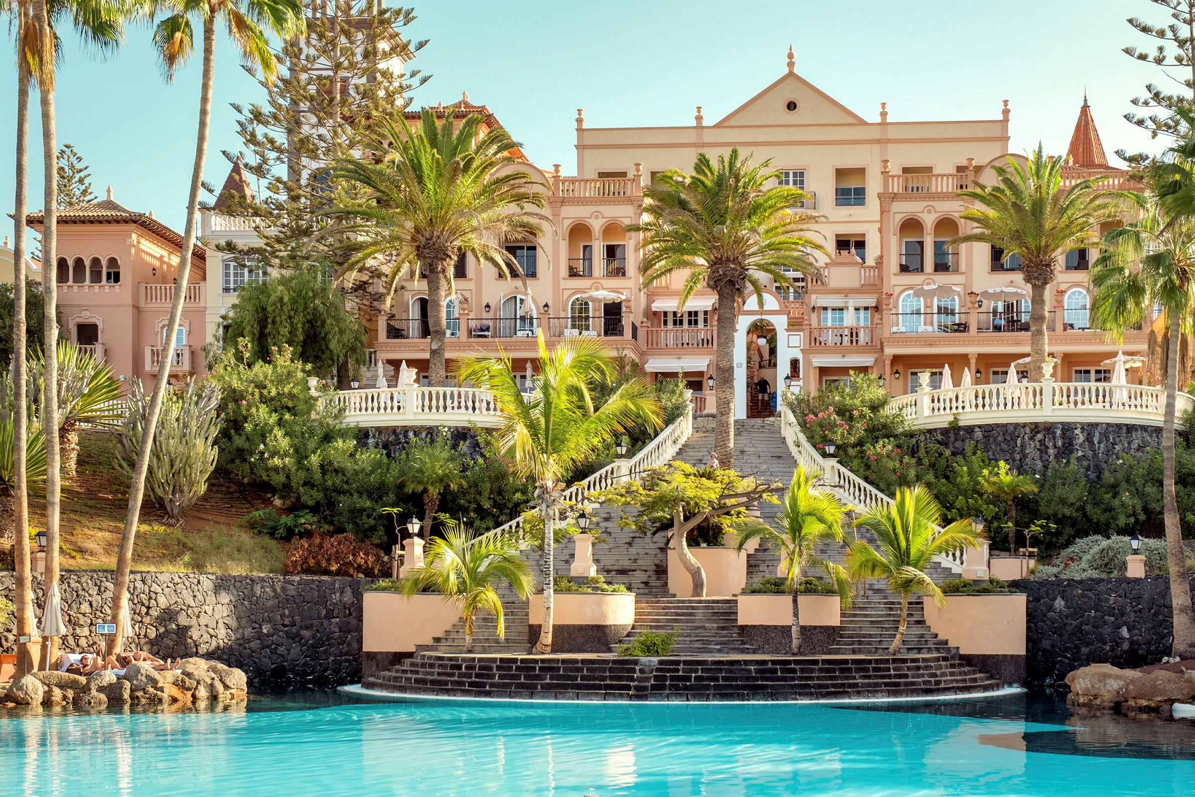 Bild av ett hotell med palmer och pool. (AI-genererad text)