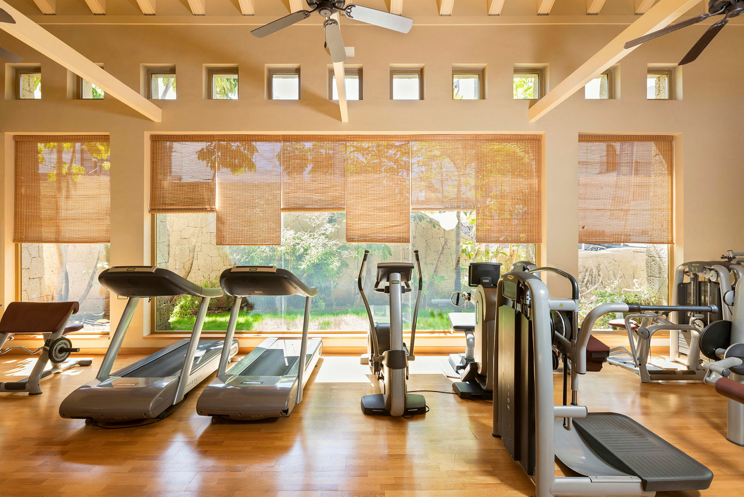 Ett gym med träningsutrustning och stora fönster. (AI-genererad text)