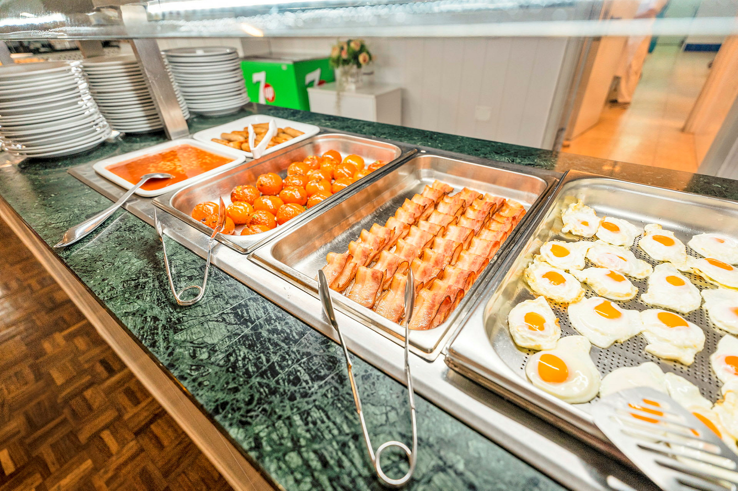Bufféservering med olika maträtter, inklusive stekta ägg, bacon, köttbullar och tomatsås. (AI-genererad text)