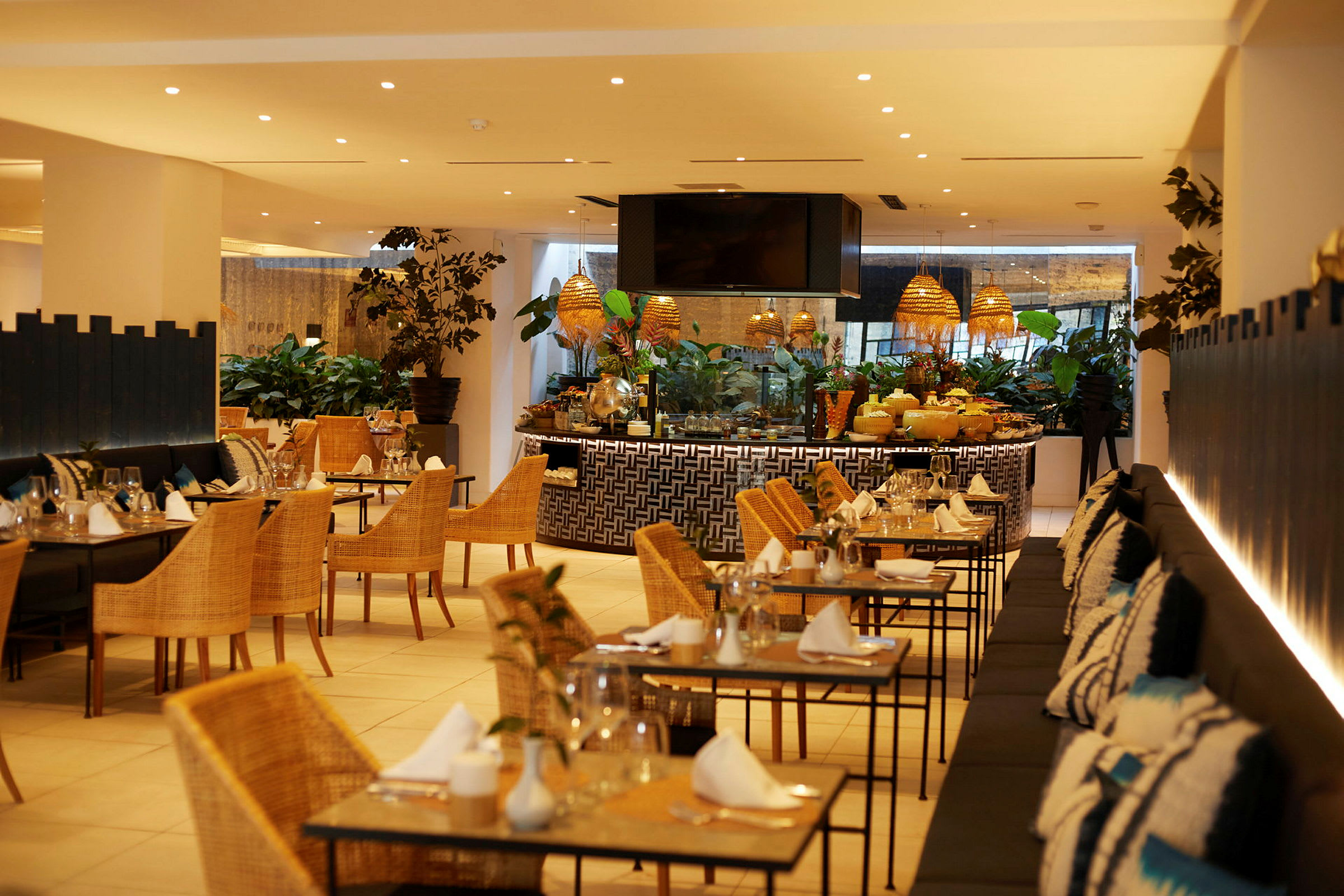 Interiör av en restaurang med dukade bord och rottingstolar. (AI-genererad text)