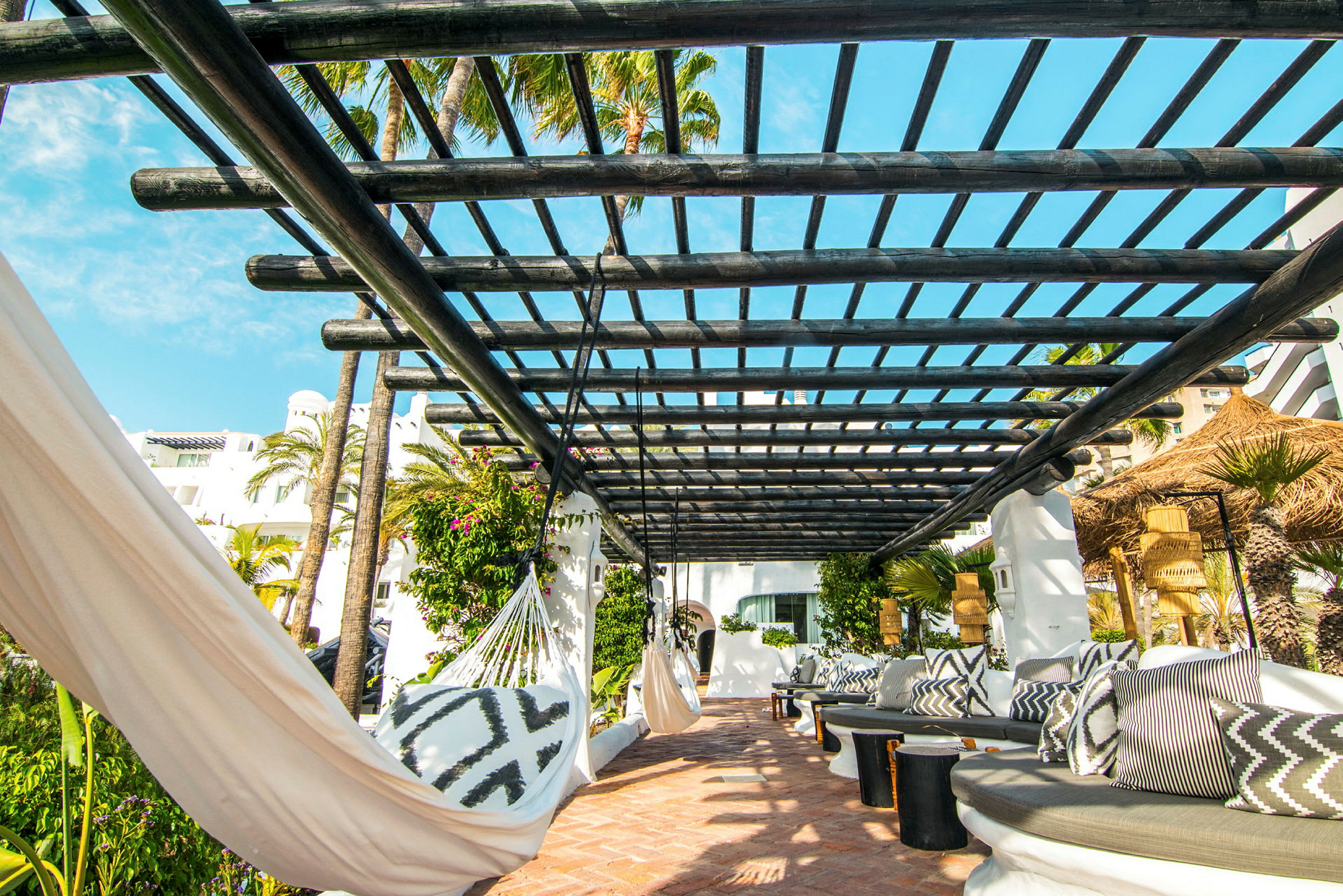 Utomhusområde med pergola, hängmattor och sittplatser. (AI-genererad text)