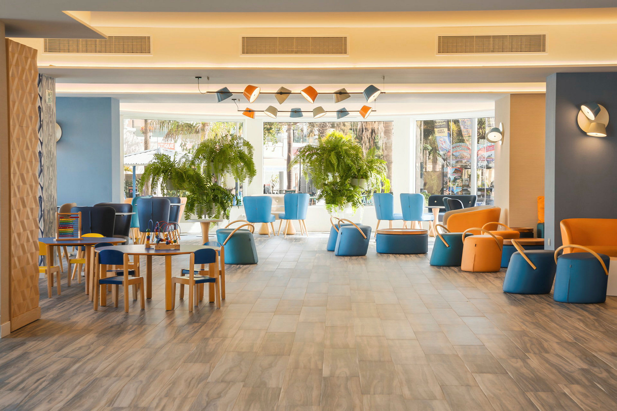 Ett färgglatt hotellområde med sittplatser och växter. (AI-genererad text)