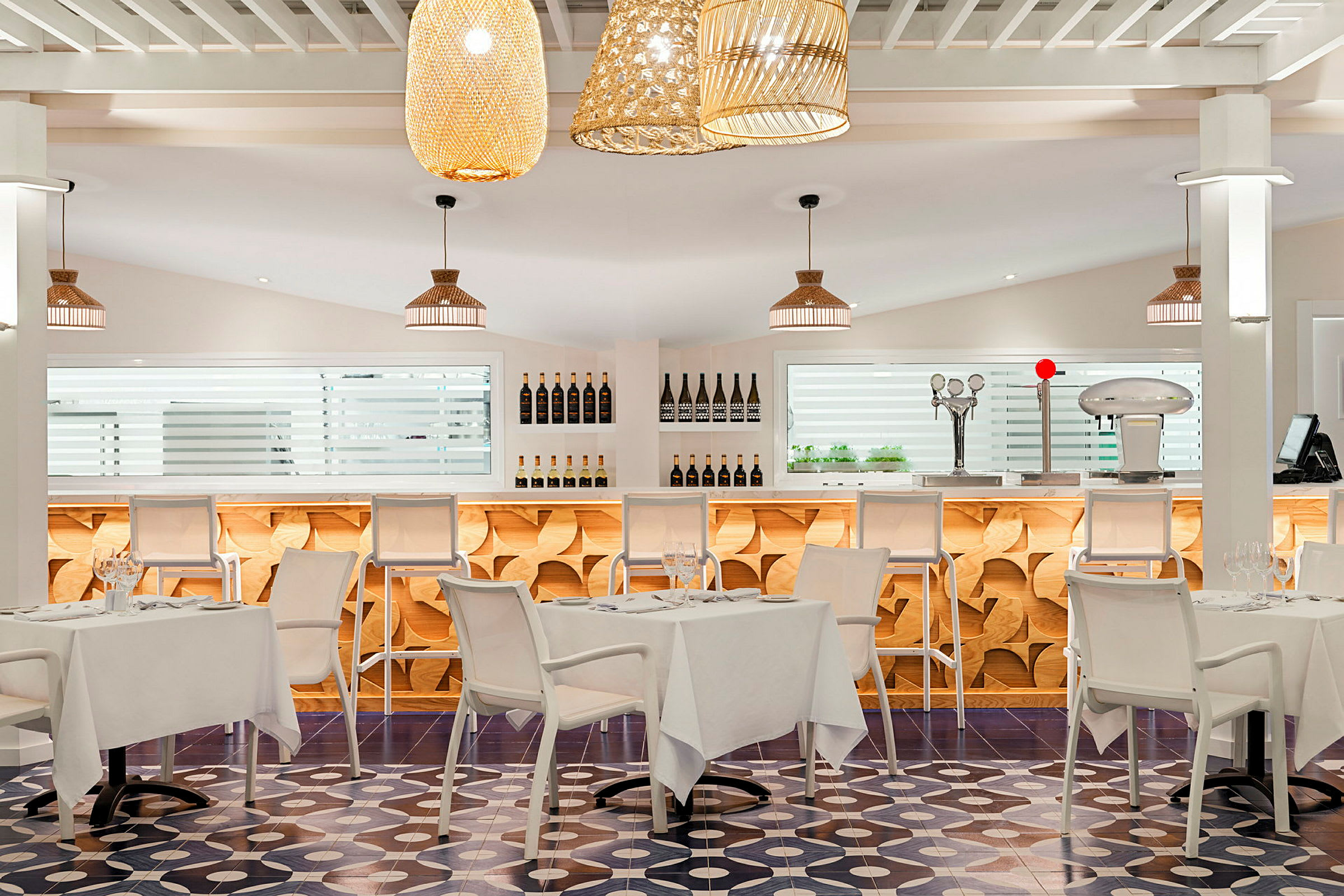 Modernt inredd restaurang med ljusa färger, stilrena bord och stolar samt bar i bakgrunden. (AI-genererad text)