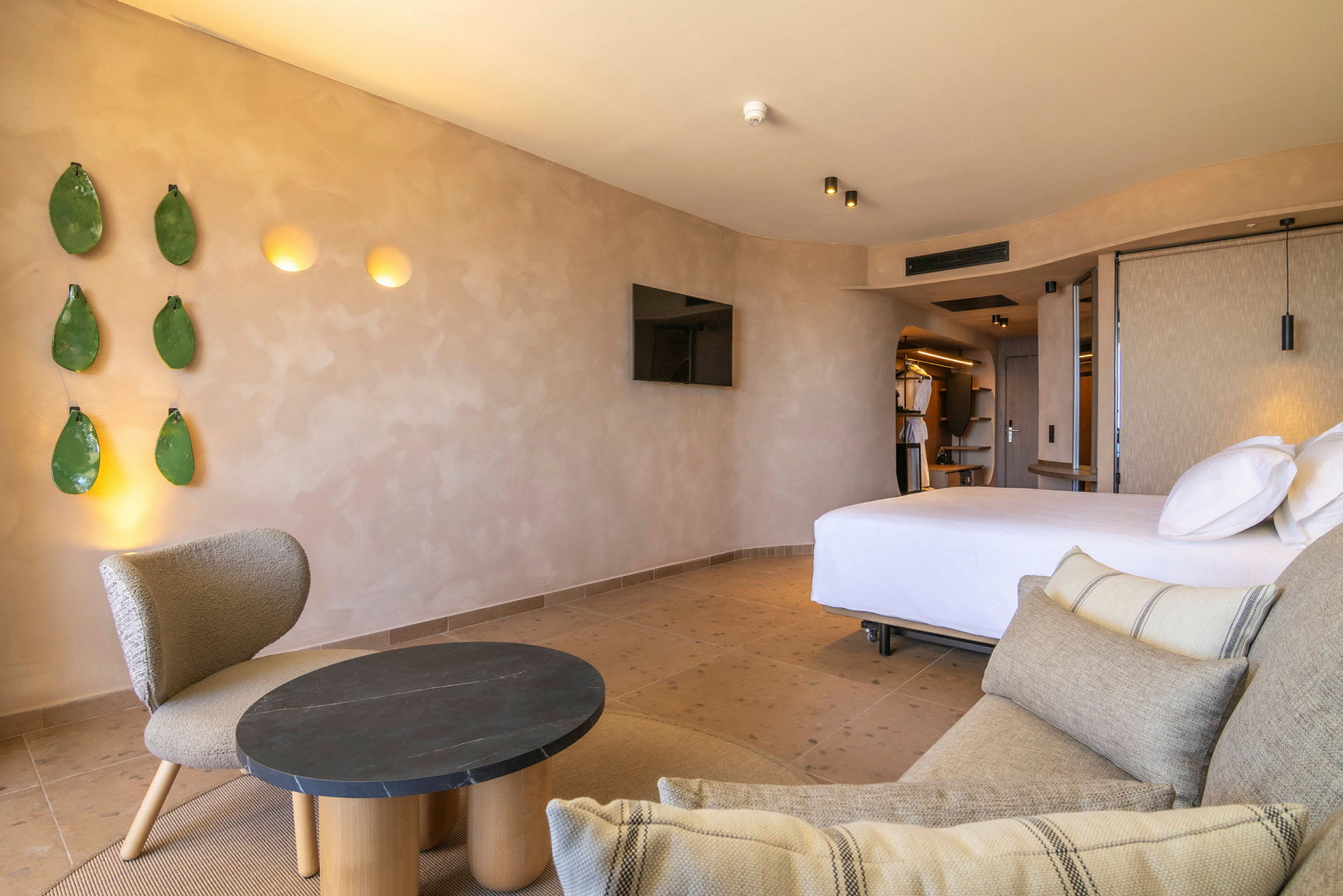 Bild på ett hotellrum med modern inredning, inklusive en säng, en soffa och en fåtölj. (AI-genererad text)