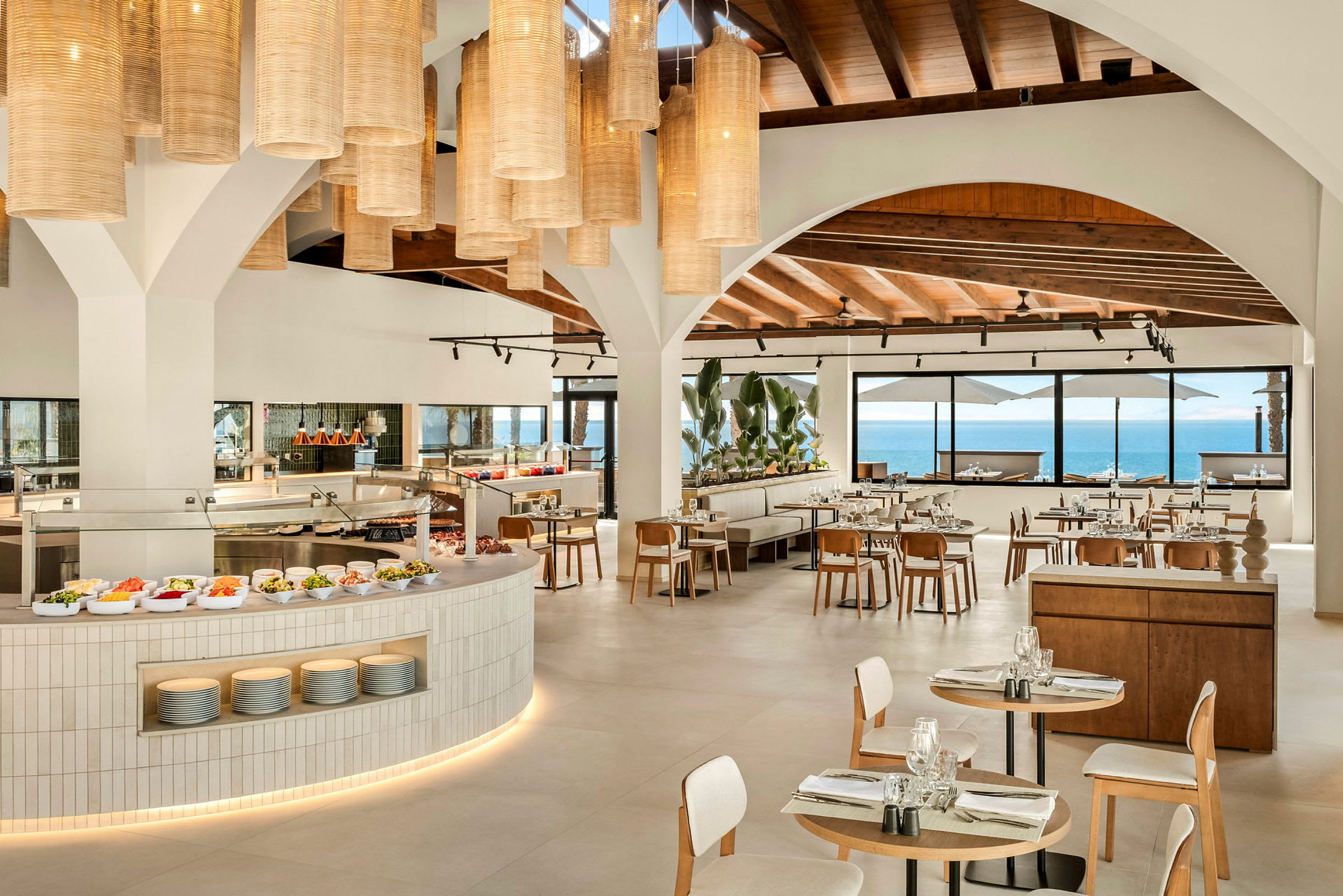 En modern restaurang med öppet kök och fönster med havsutsikt. (AI-genererad text)