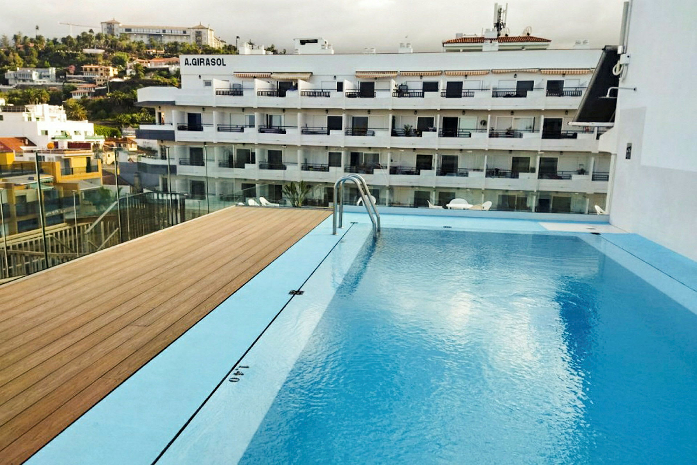 Bild av en swimmingpool med utsikt över ett flerfamiljshus i bakgrunden. (AI-genererad text)