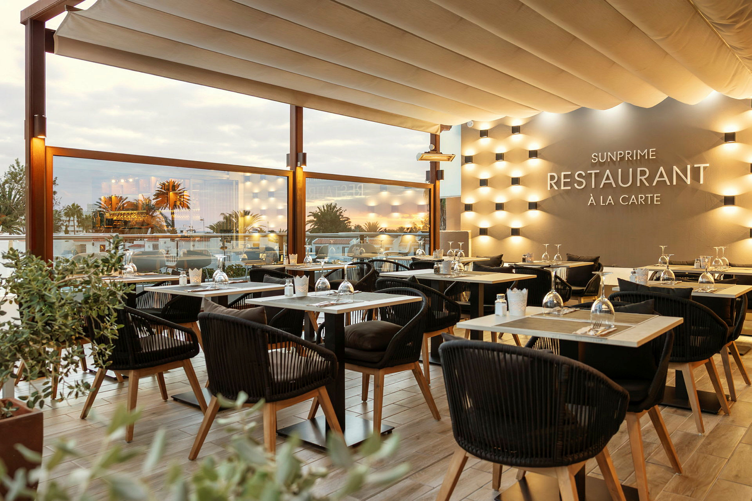 Solbelyst restaurangmiljö med elegant uppsatta bord och stolar. (AI-genererad text)