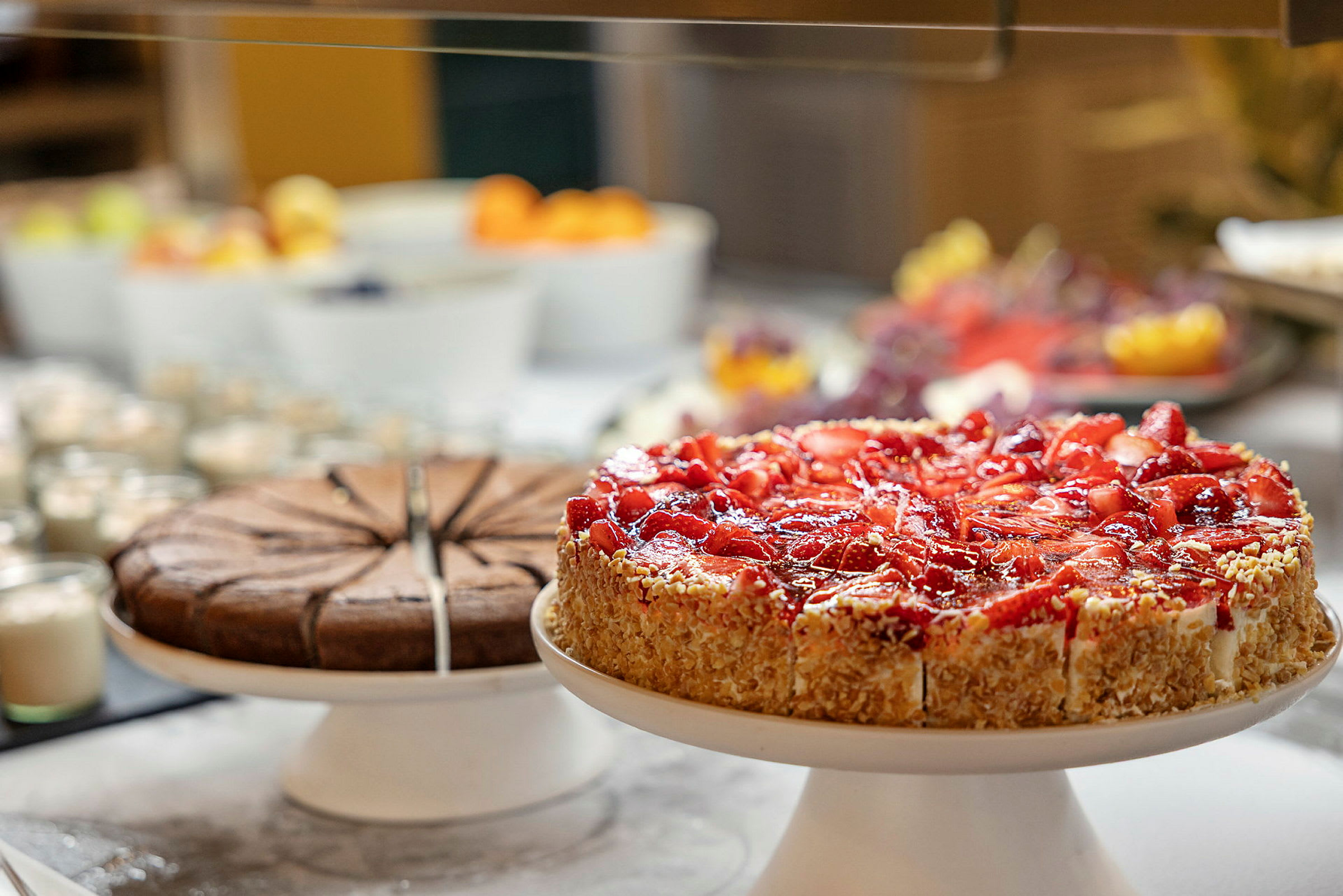 En bild som visar två tårtor, en chokladtårta och en jordgubbstårta, på ett buffébord. (AI-genererad text)