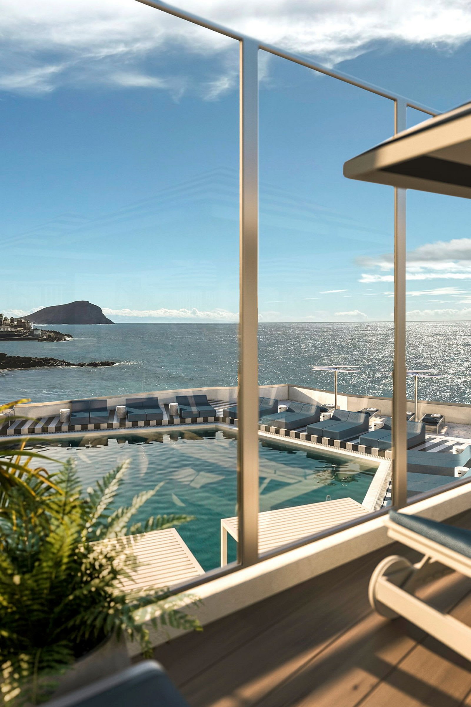 Utsikt över en pool och solstolar med havet i bakgrunden. (AI-genererad text)