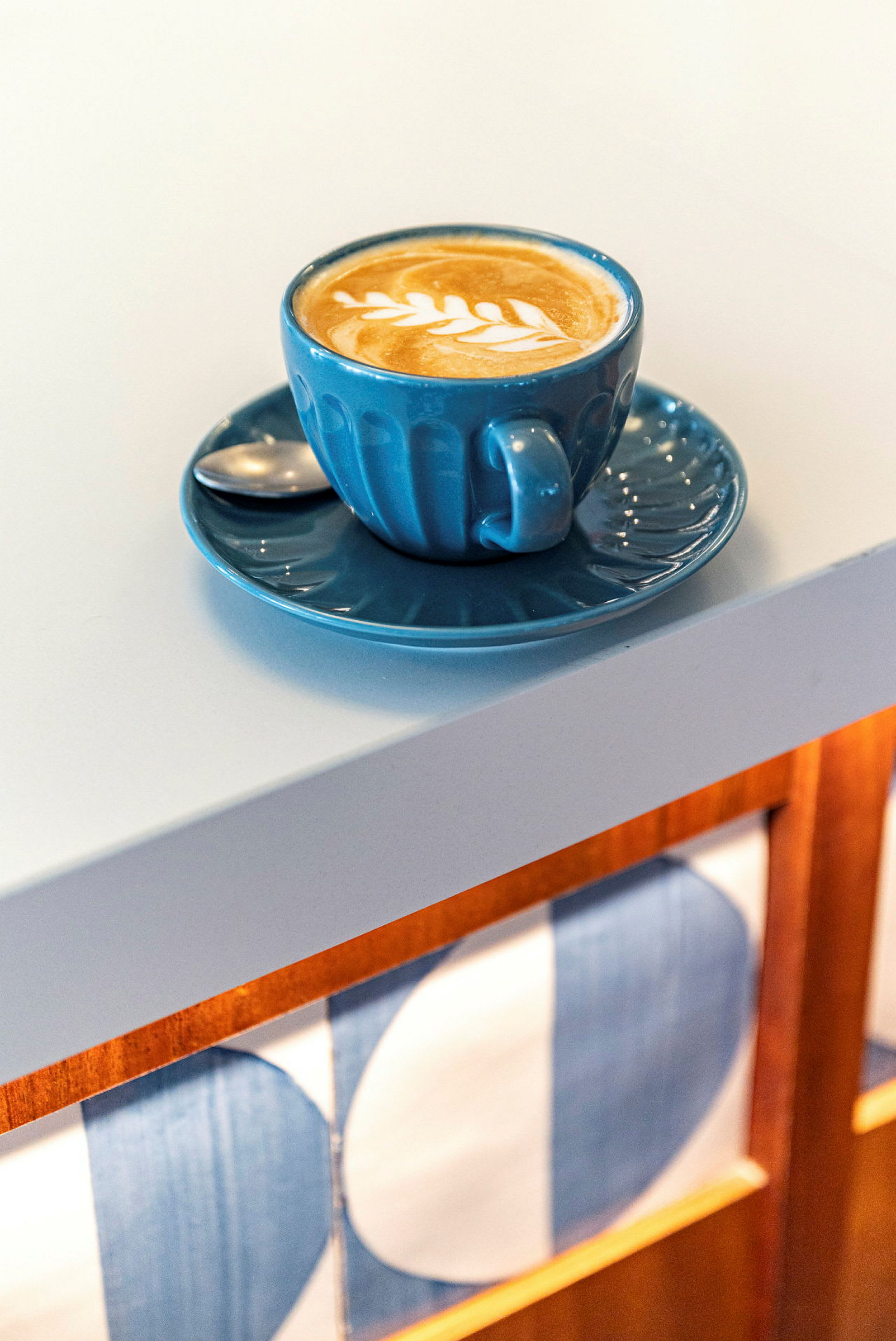 En kopp kaffe med latte art på ett vitt bord. (AI-genererad text)