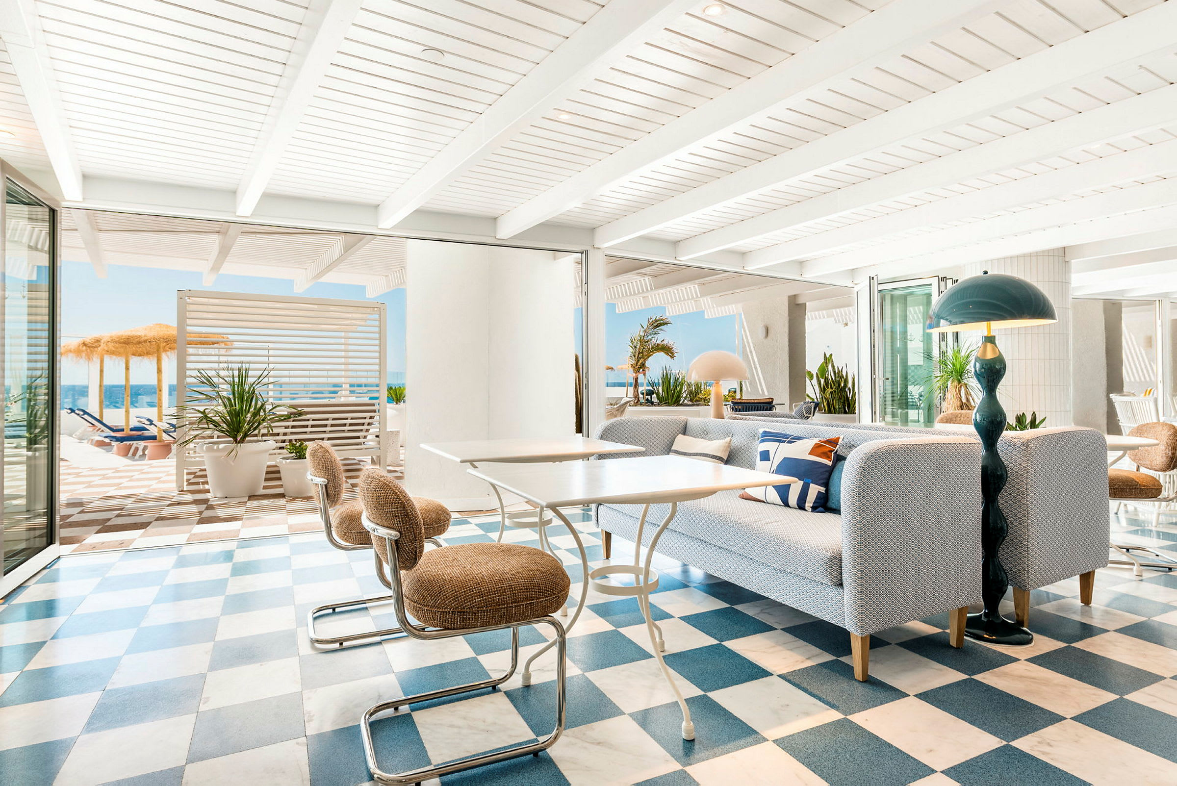 Ljus och modern lounge med rutigt golv och utsikt mot en solterrass. (AI-genererad text)