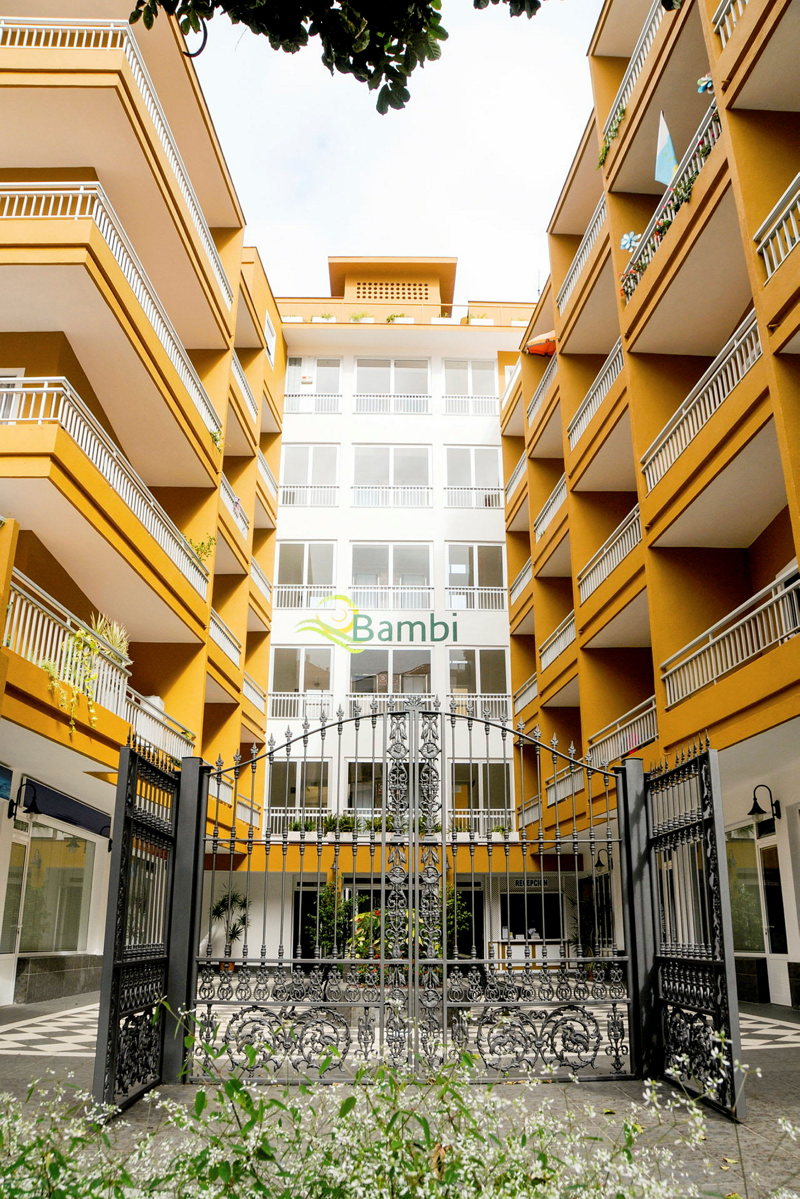 Entré till hotellkomplex med flera våningar och balkonger. (AI-genererad text)