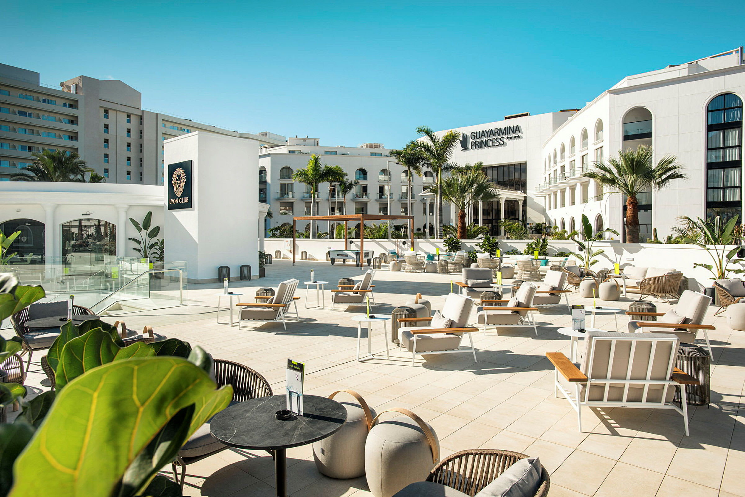 Bild av en utomhusterrass vid Guayarmina Princess hotell med solstolar och modern inredning. (AI-genererad text)