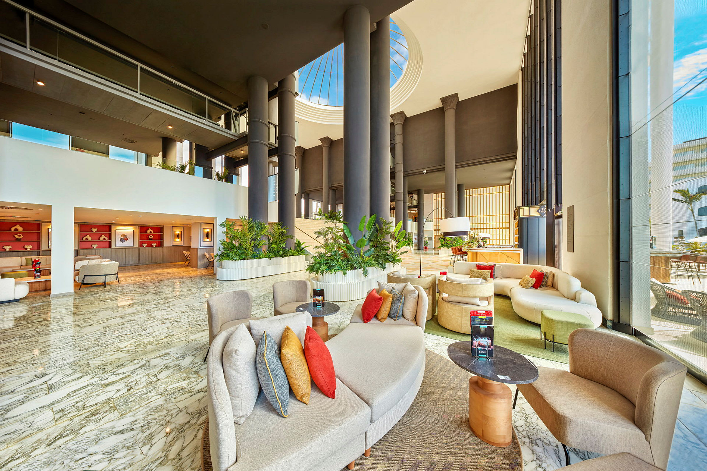 Modern hotellobby med marmorgolv, sittplatser och gröna växter. (AI-genererad text)