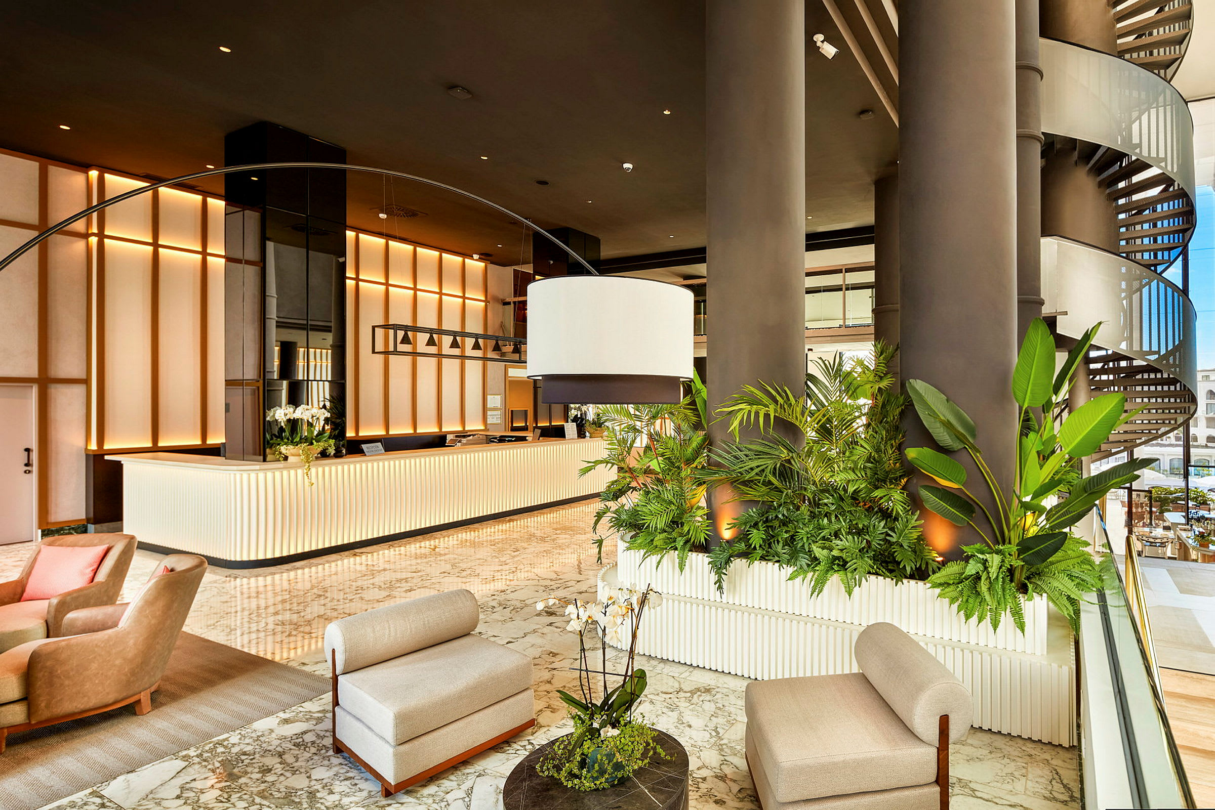 Ljus hotellobby med reception, gröna växter och sittmöbler. (AI-genererad text)