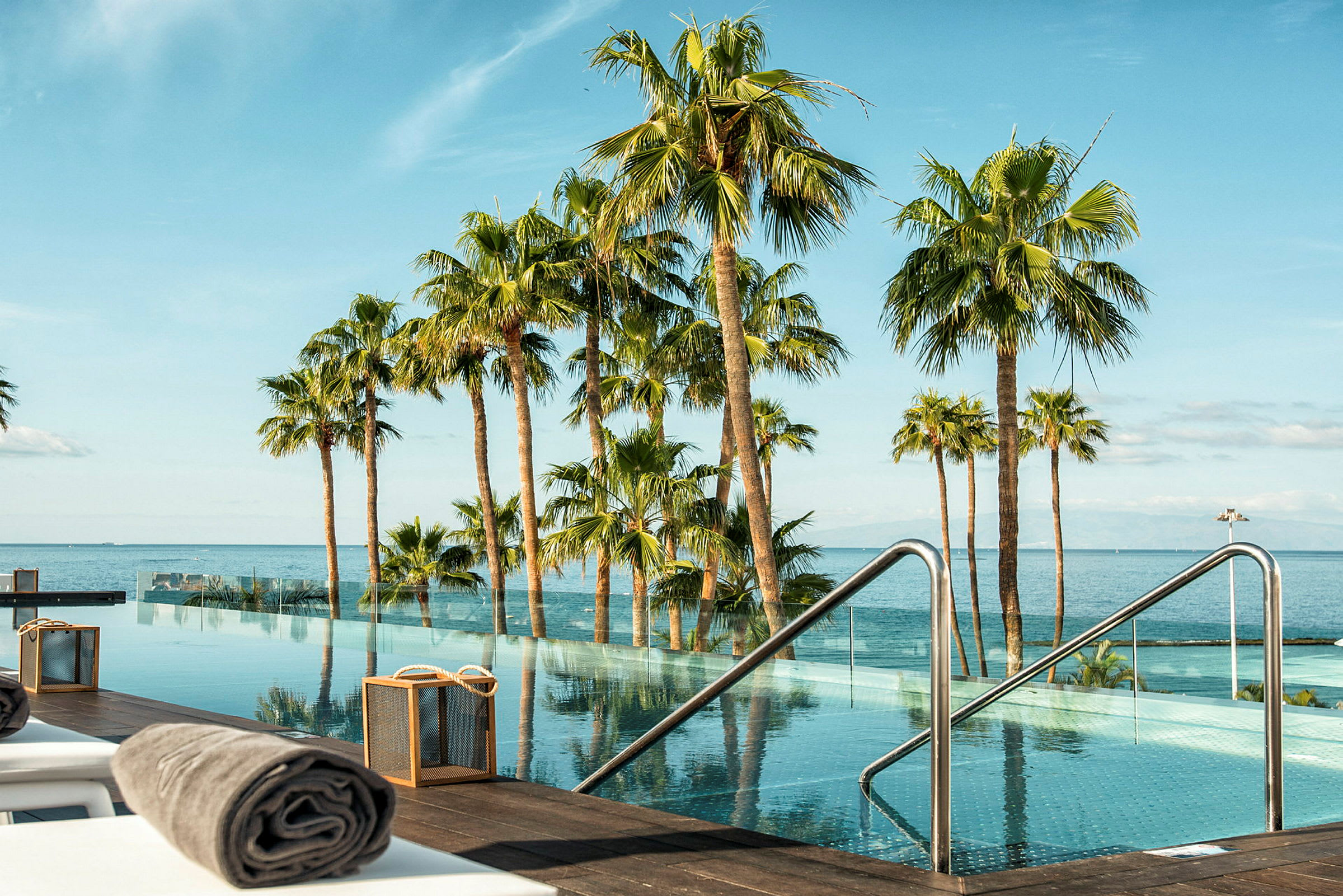 Palmer vid en infinitypool med utsikt över havet. (AI-genererad text)