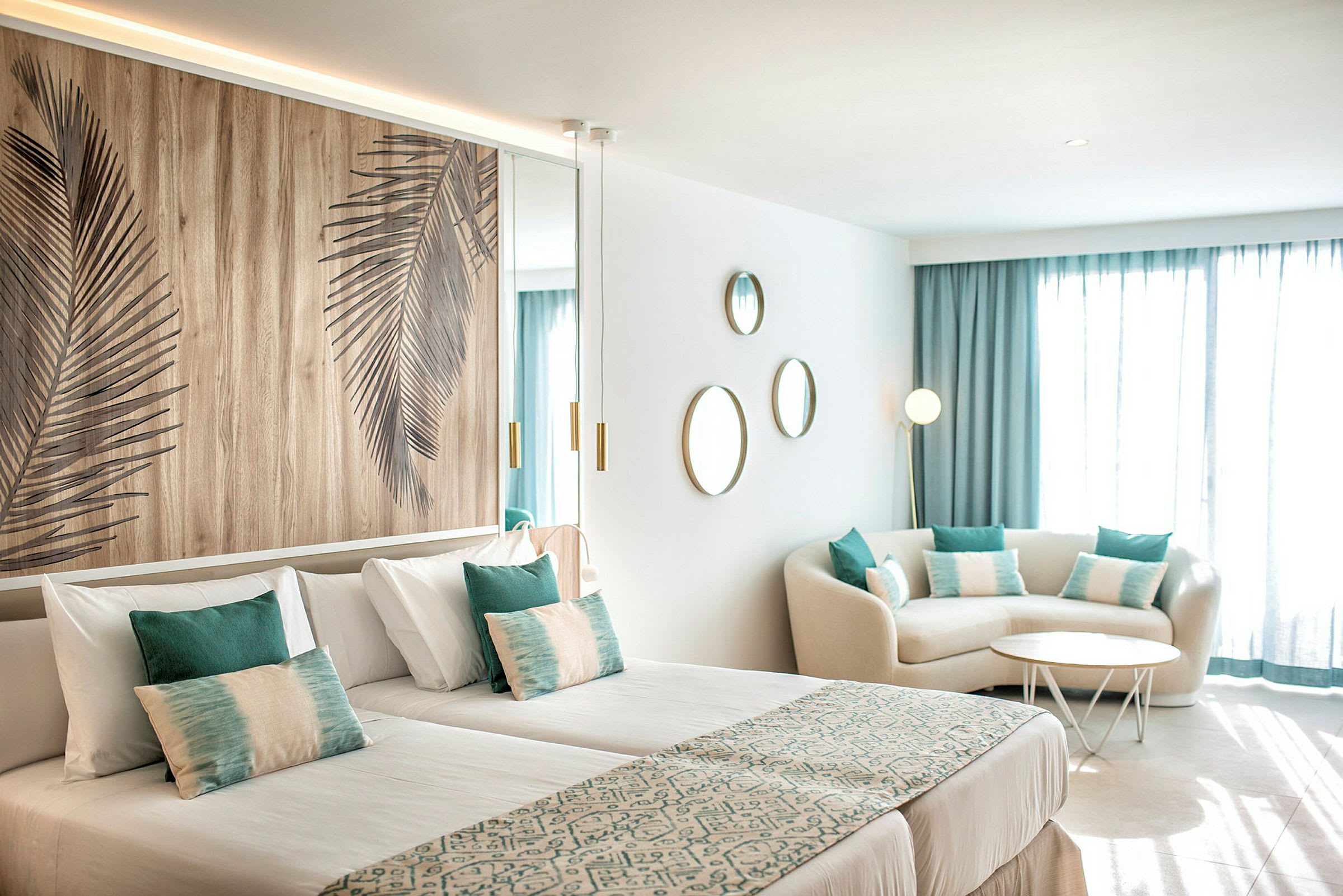 Ett modernt hotellrum med två enkelsängar, sittgrupp och dekorationer. (AI-genererad text)