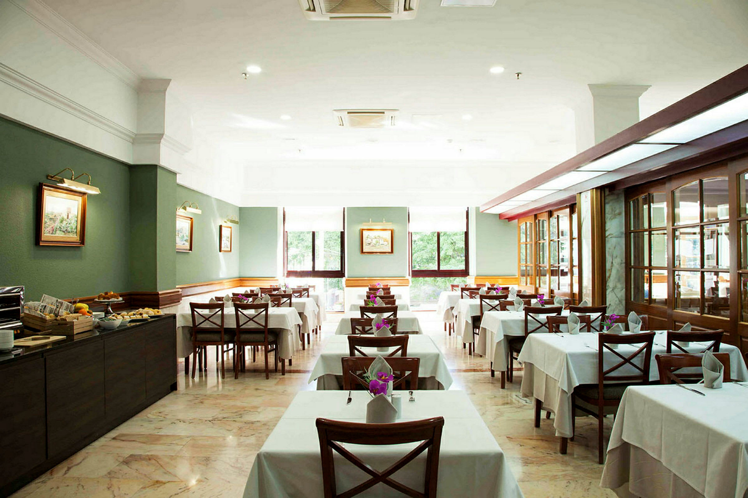 Interiör av en restaurang med dukade bord och stolar. (AI-genererad text)