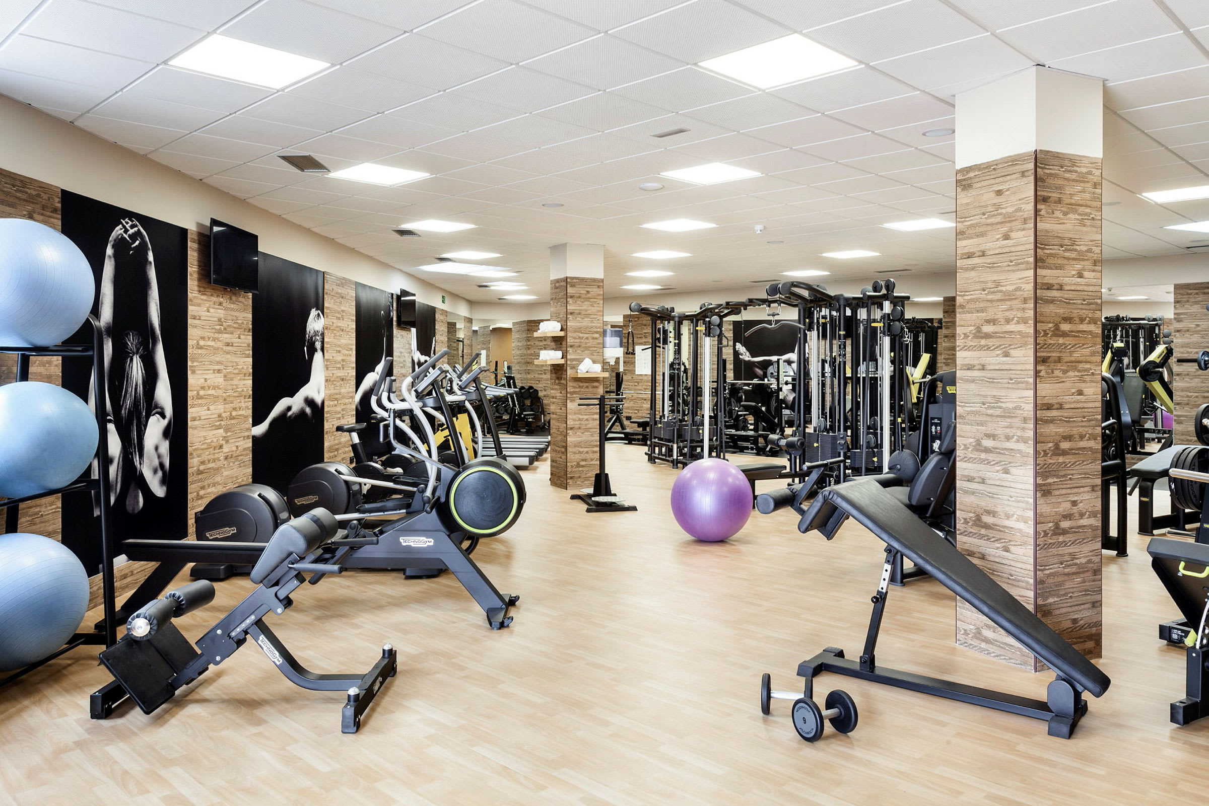 Interiör av ett gym med träningsmaskiner och utrustning. (AI-genererad text)