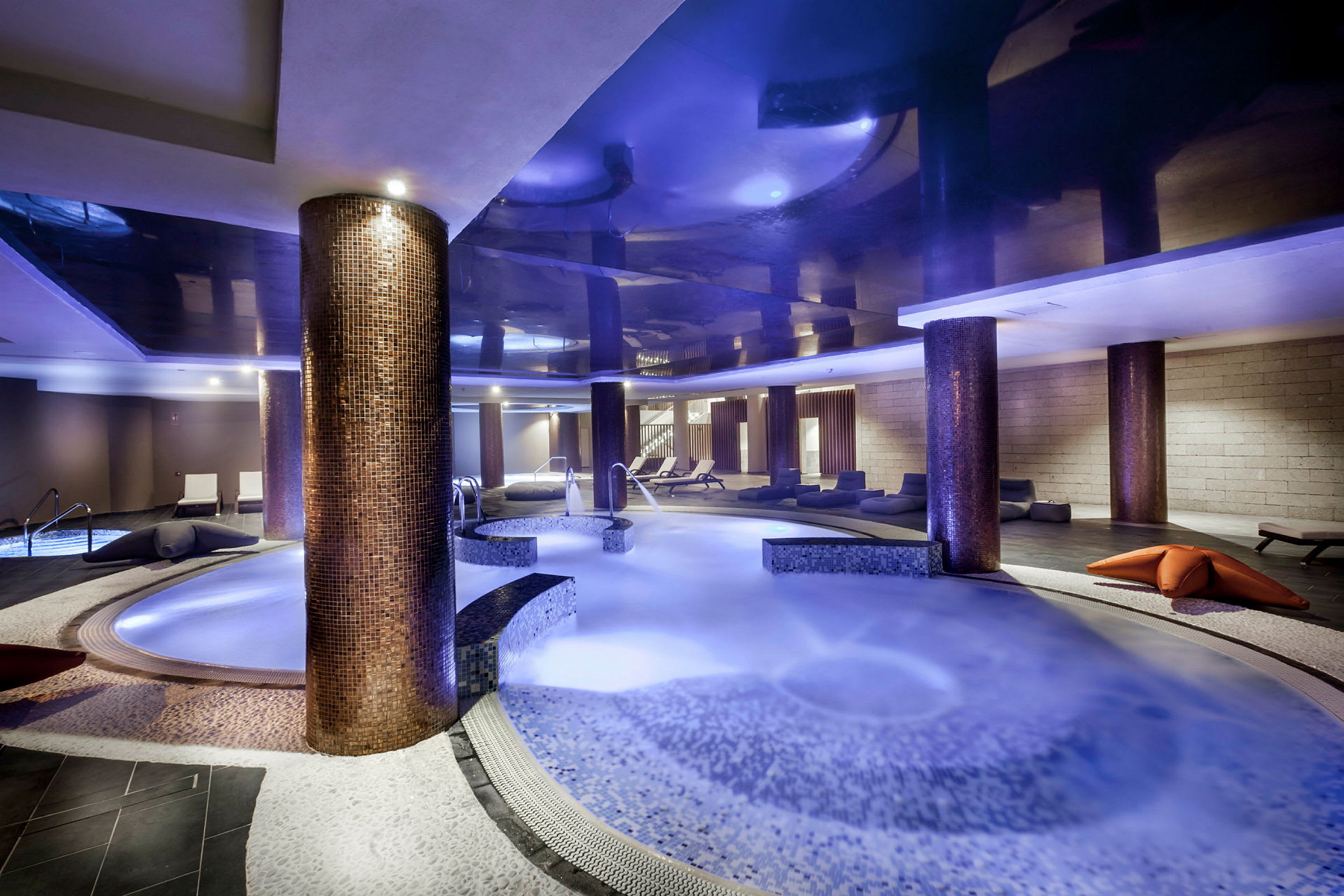 Inomhusspa med bubbelpool och loungestolar. (AI-genererad text)