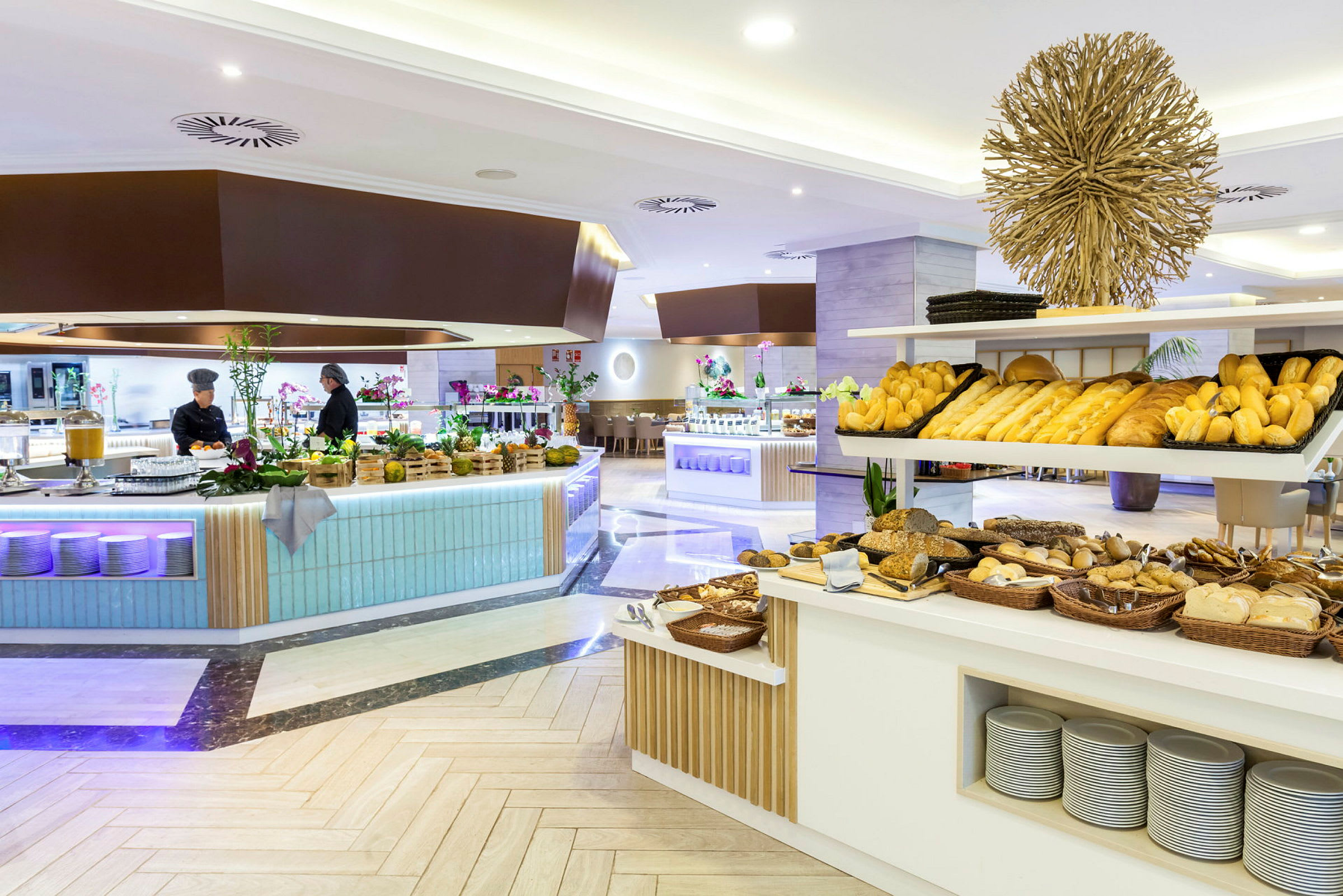 Interiör av en modern hotellbuffé med olika sorters bröd och bakverk på display. (AI-genererad text)
