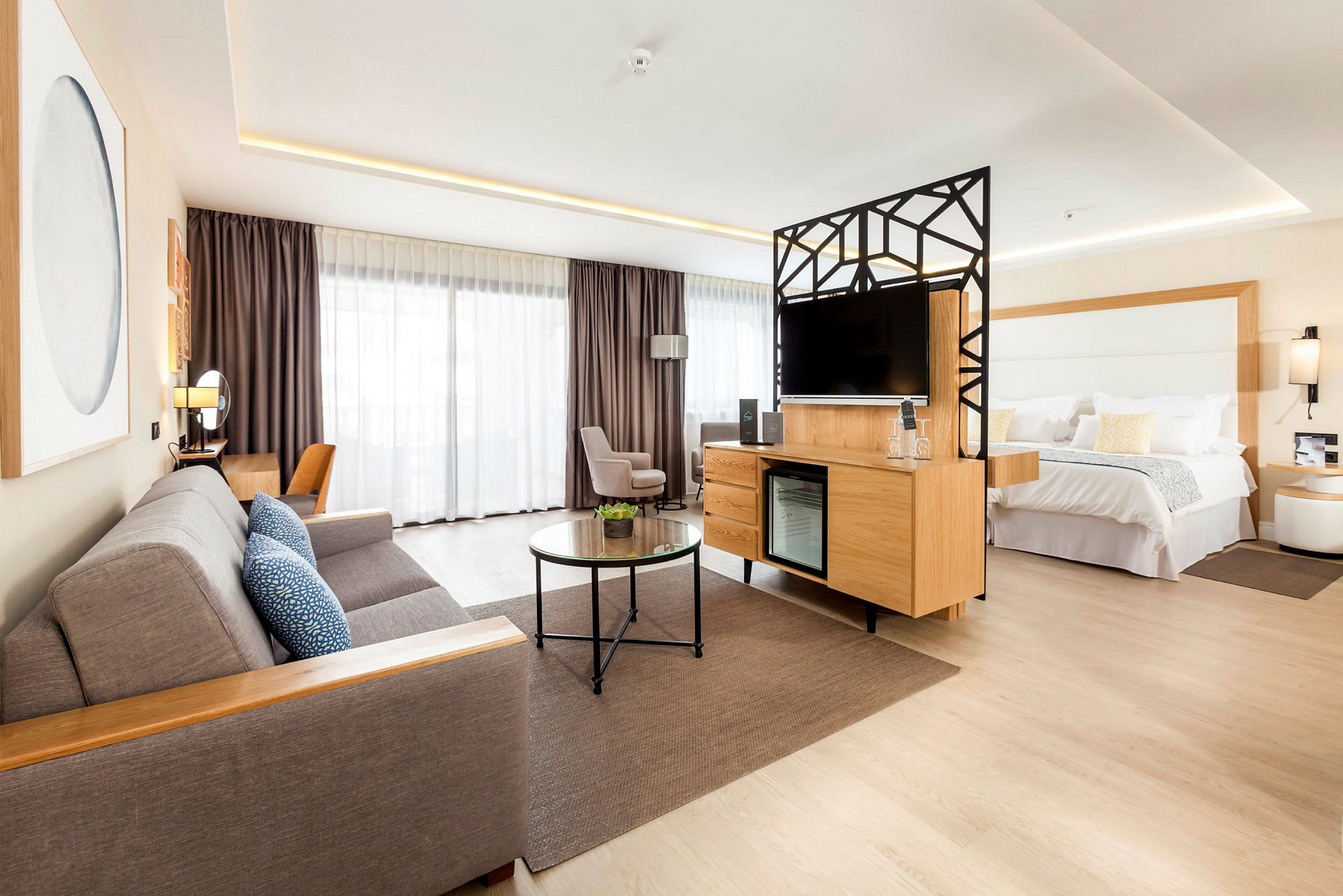 Ett modernt hotellrum med vardagsrumsdel och dubbelsäng. (AI-genererad text)